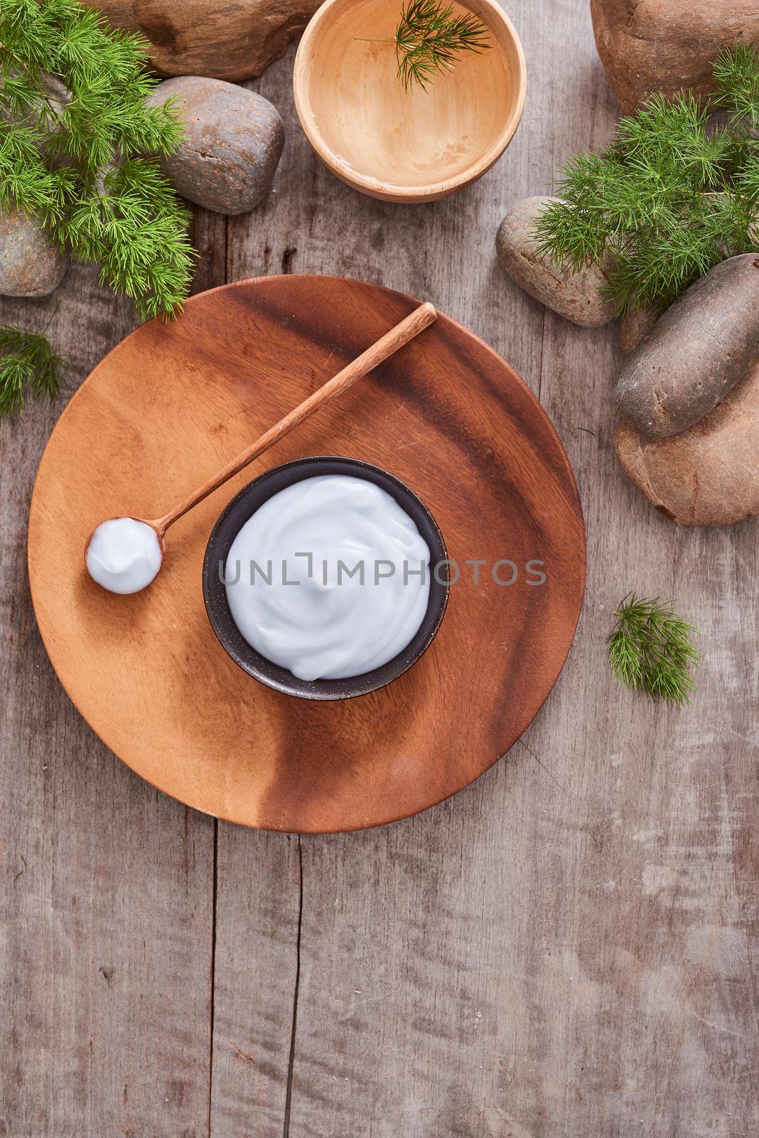 cosmetic cream and fresh  leaves on wooden table background by makidotvn