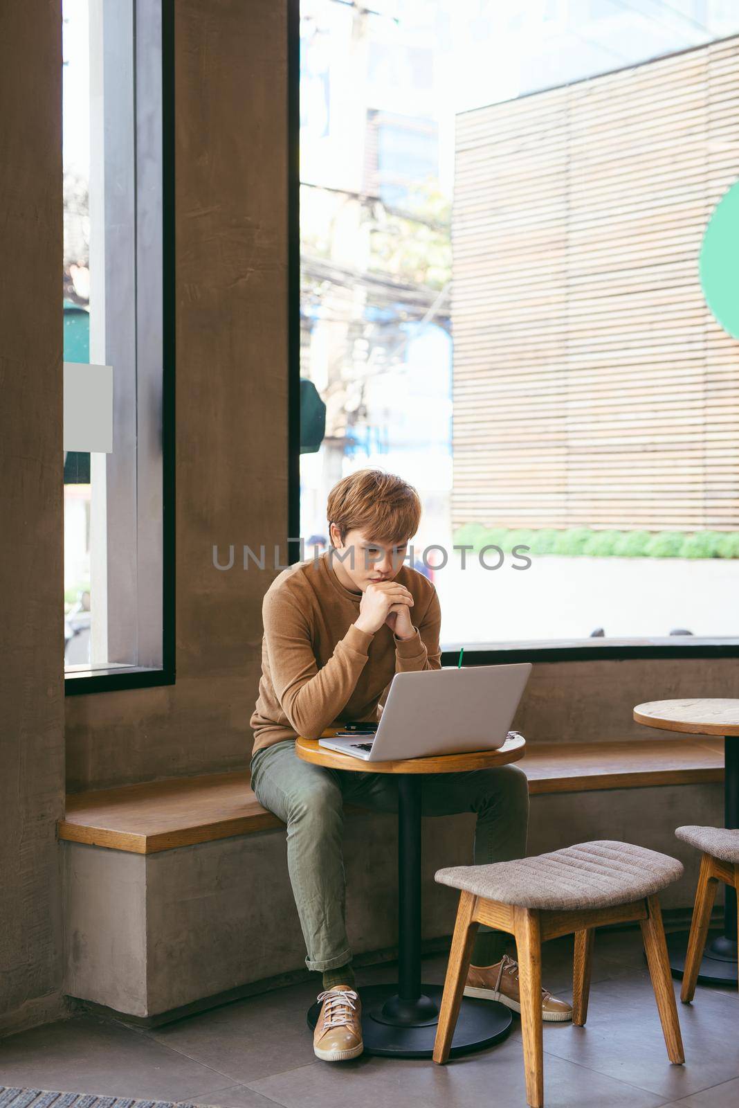 Modern business man connecting to wireless on his laptop computer during coffee break, male freelancer drink tea while working on notebook in loft studio, university student working at cafe or library by makidotvn