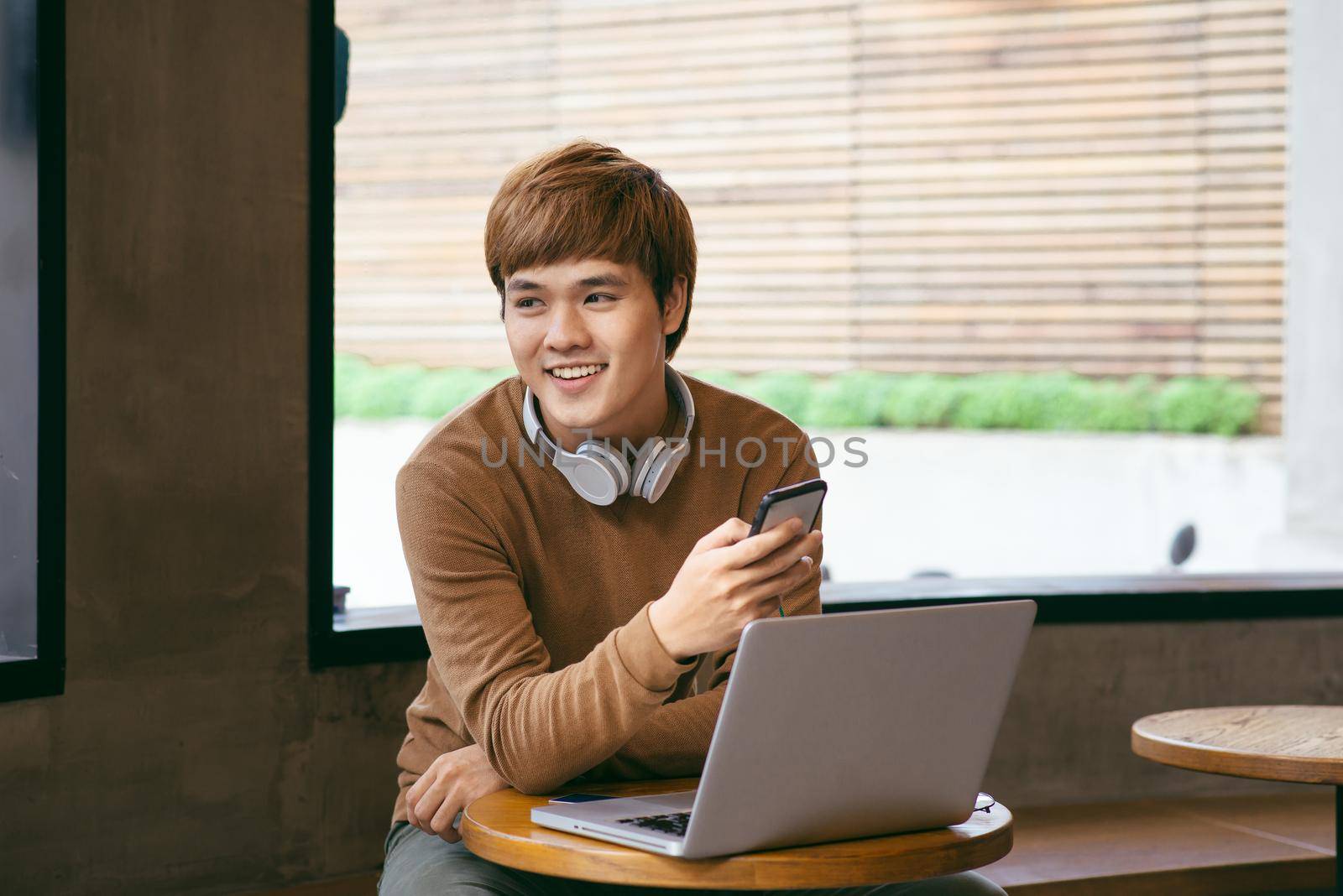 Business man working with office computer.He was sitting at the cell phone and smiling happily. by makidotvn