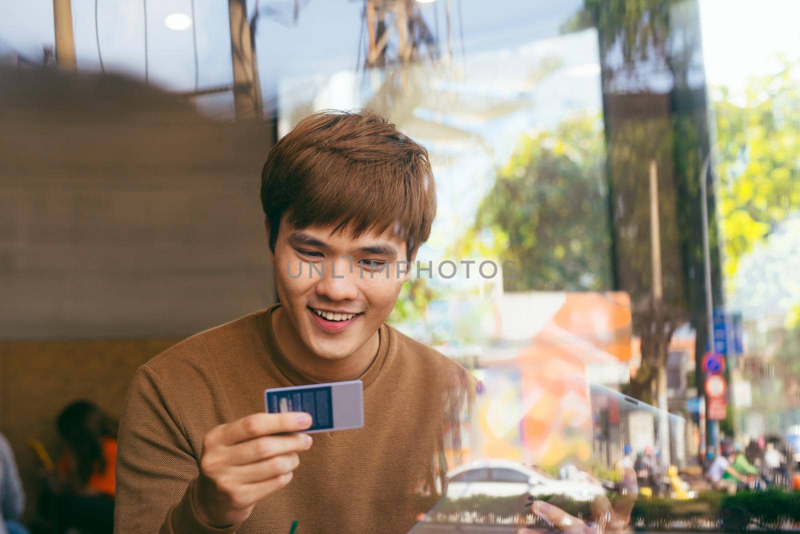 confident businessman shopping online with credit card using laptop in cafe