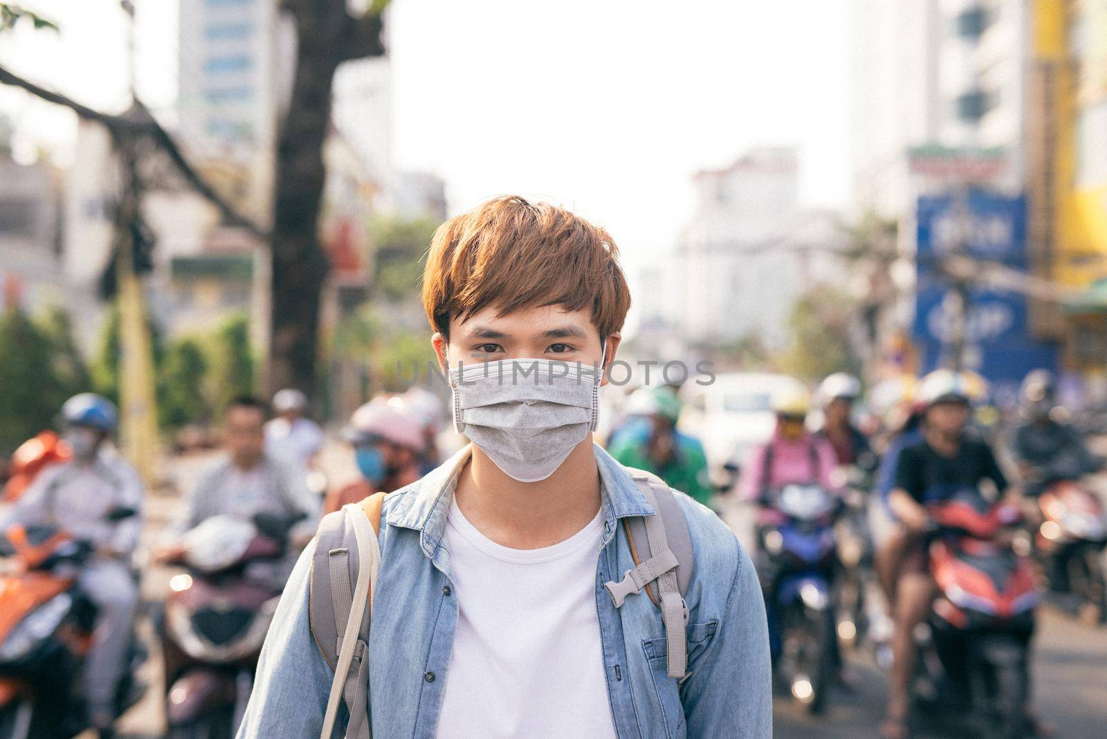 Young Asian man living in city with polluted air by makidotvn