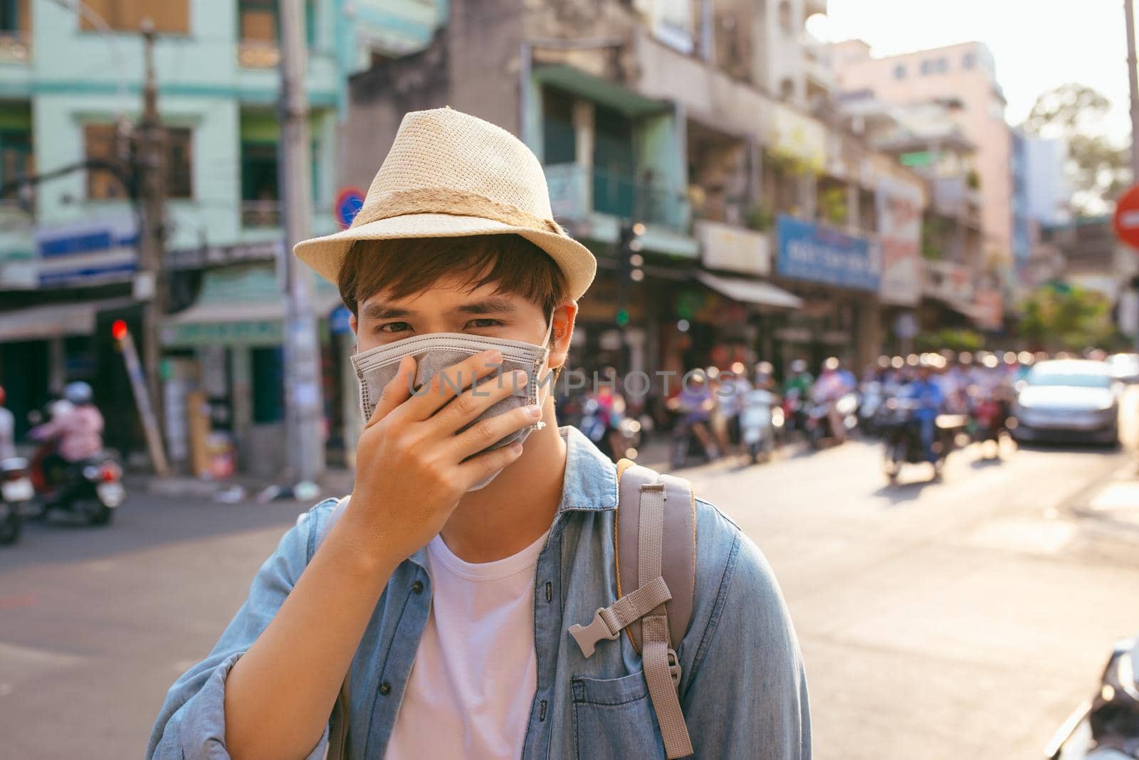 Young Asian man living in city with polluted air by makidotvn