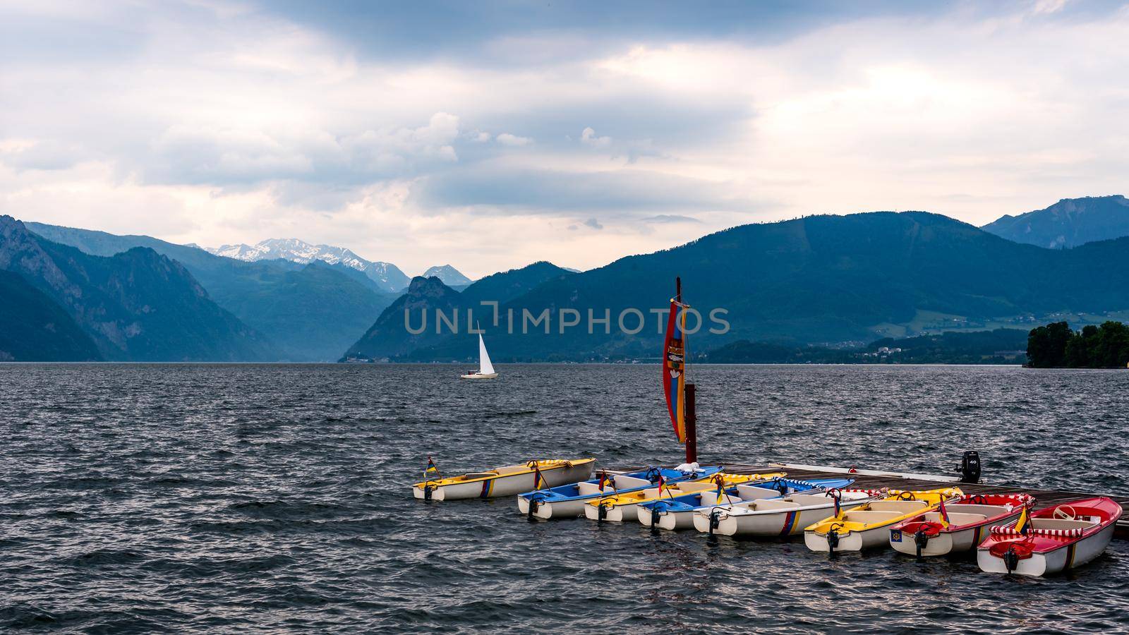 Boats moored at the pier in the lake, waiting for the coming storm, small lake waves