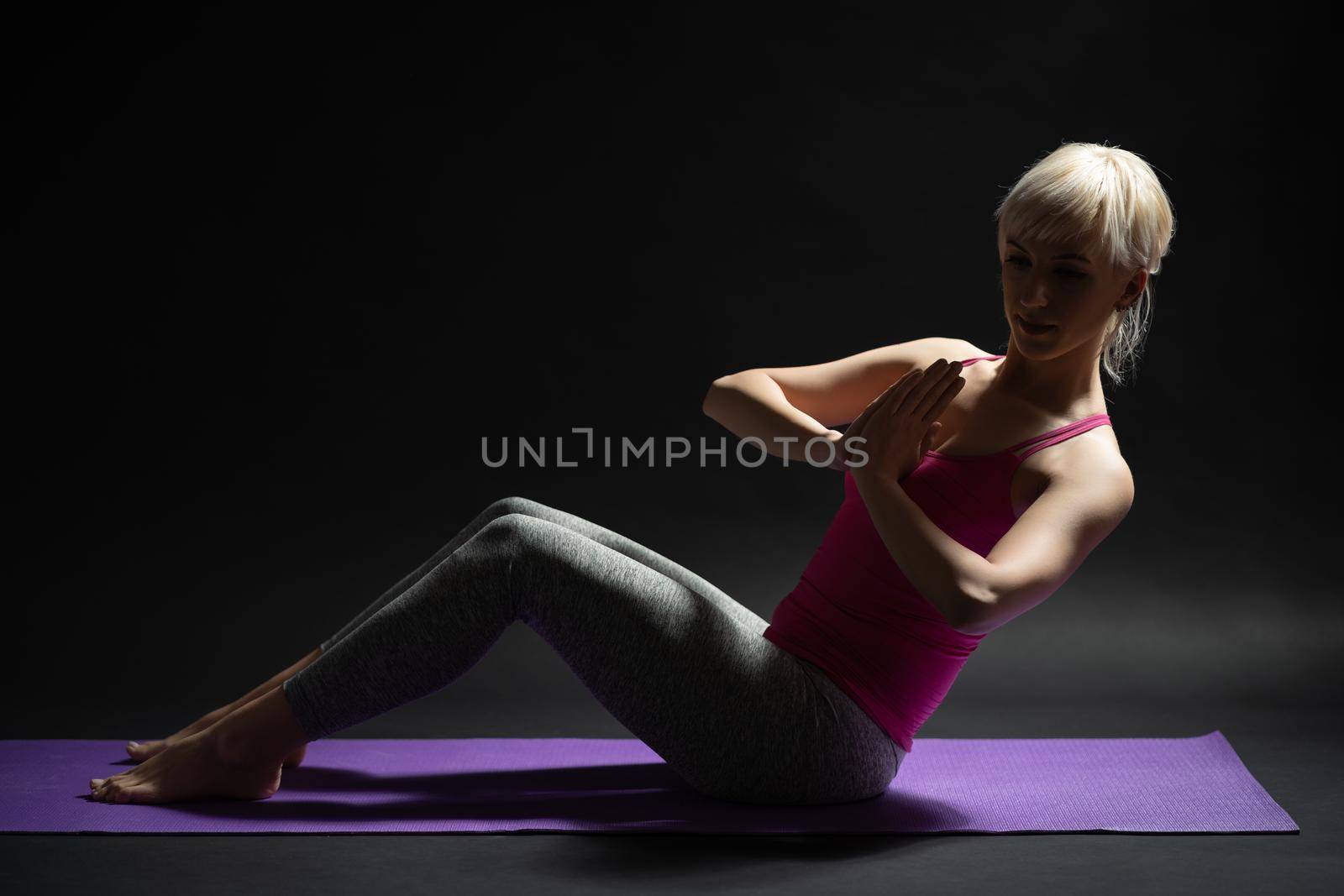 Woman exercising pilates. Russian twist exercise.