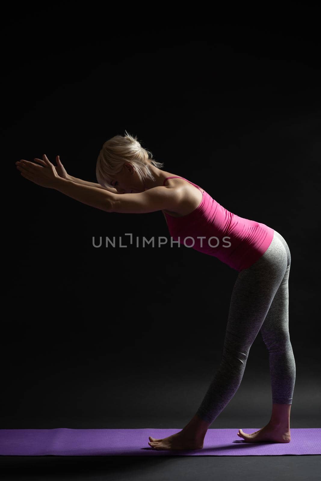 Woman exercising pilates. Variation of standing leg stretch exercise.