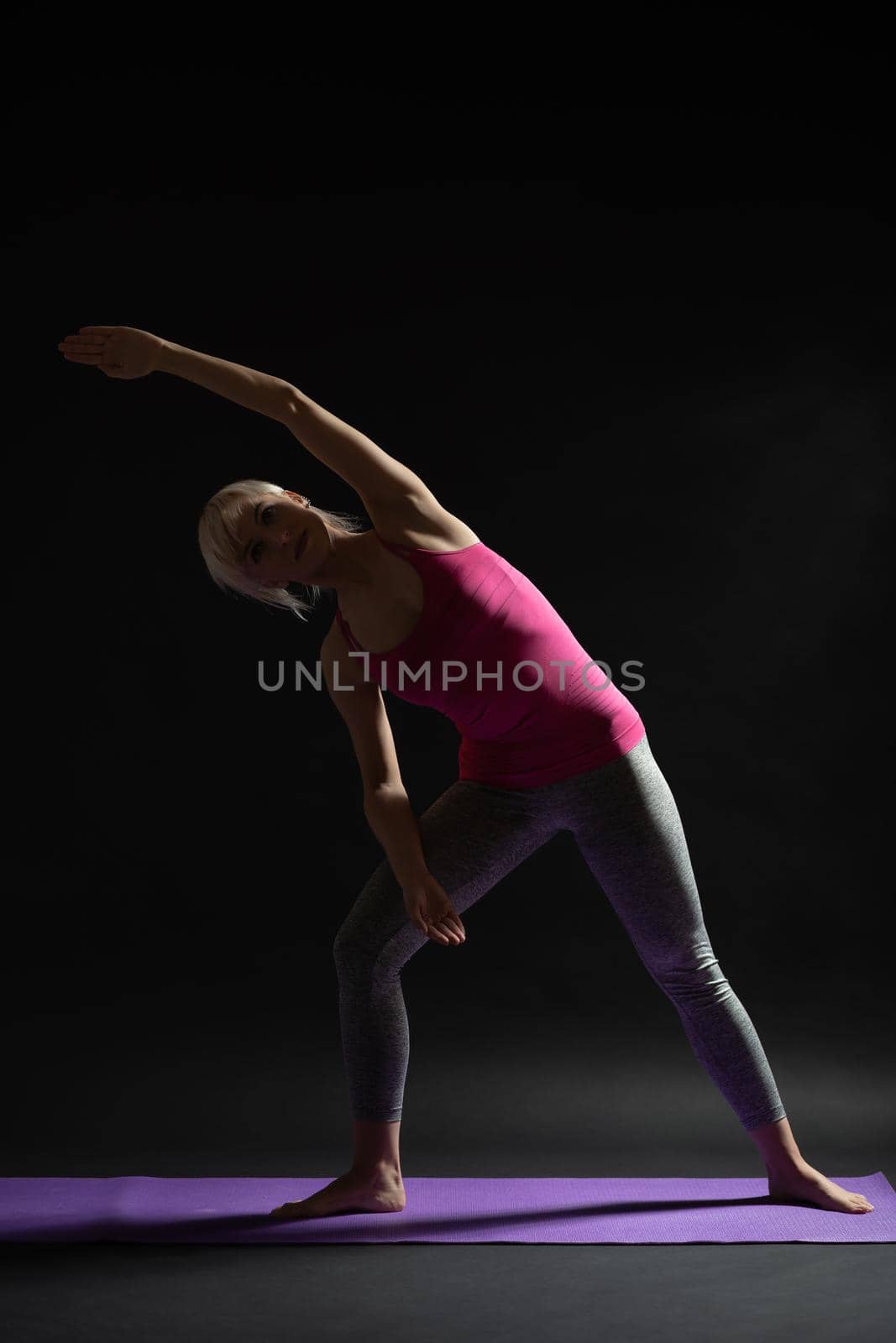 Woman exercising pilates. Variation of standing side stretch.