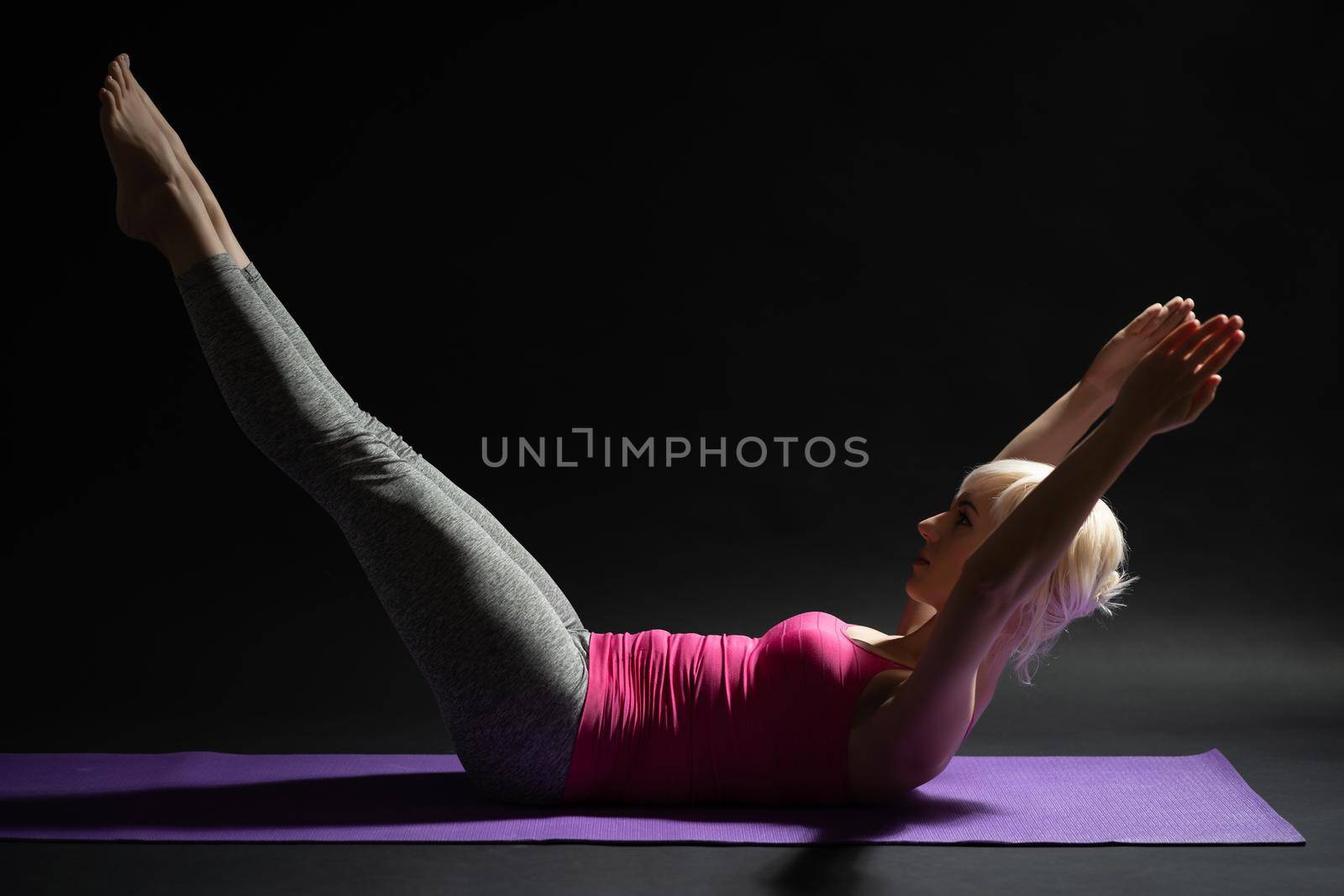 Woman exercising pilates. Double leg stretch exercise.