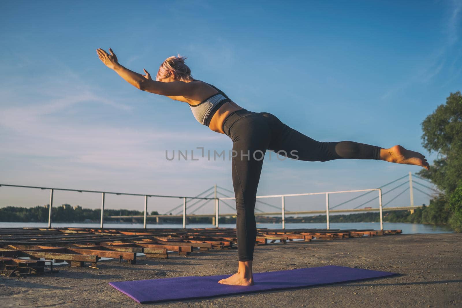 Woman practicing yoga on sunny day. Virabhadrasana / Warrior 3 pose