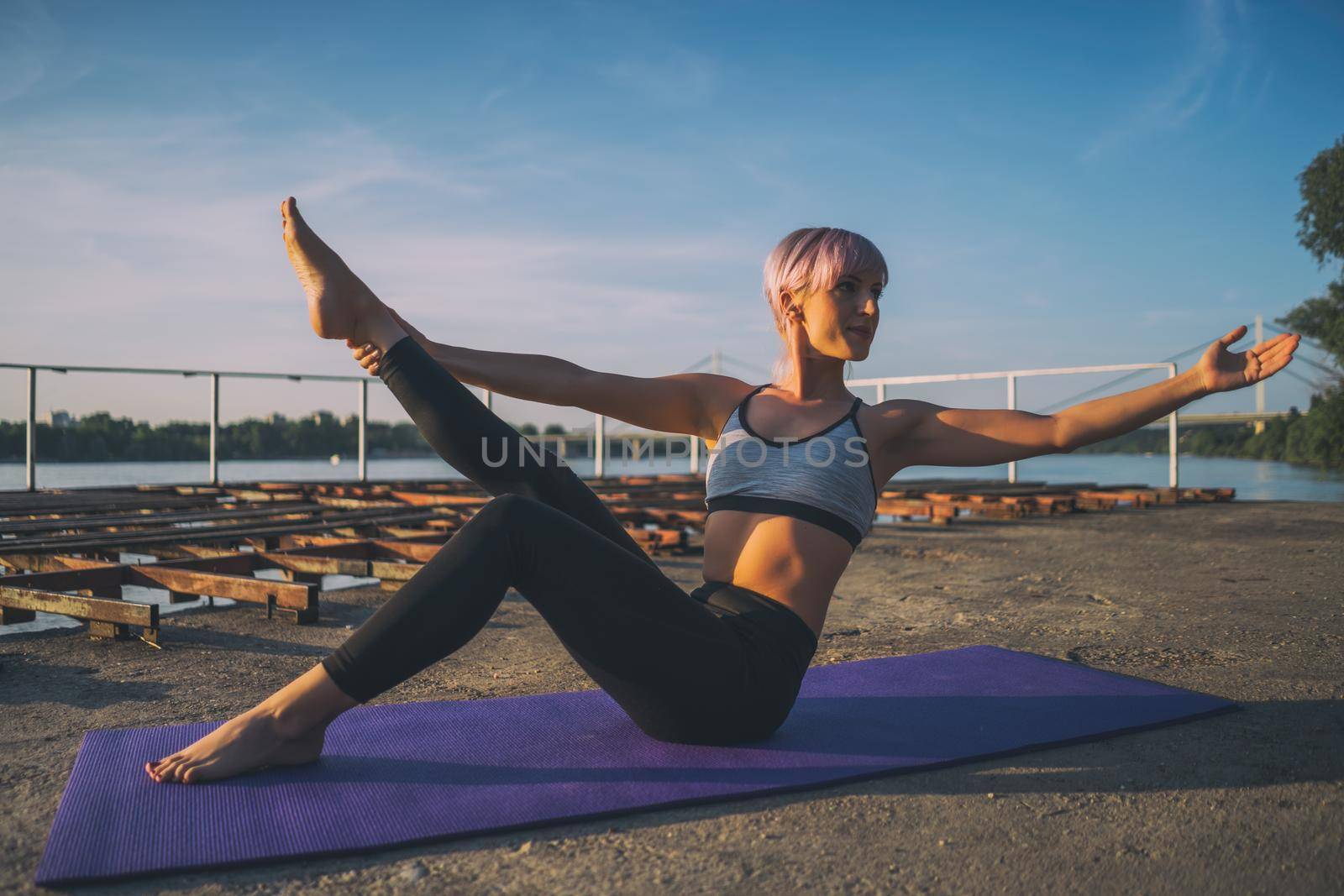 Woman practicing yoga on sunny day. Padangusthasana, Dancing Shiva Pose