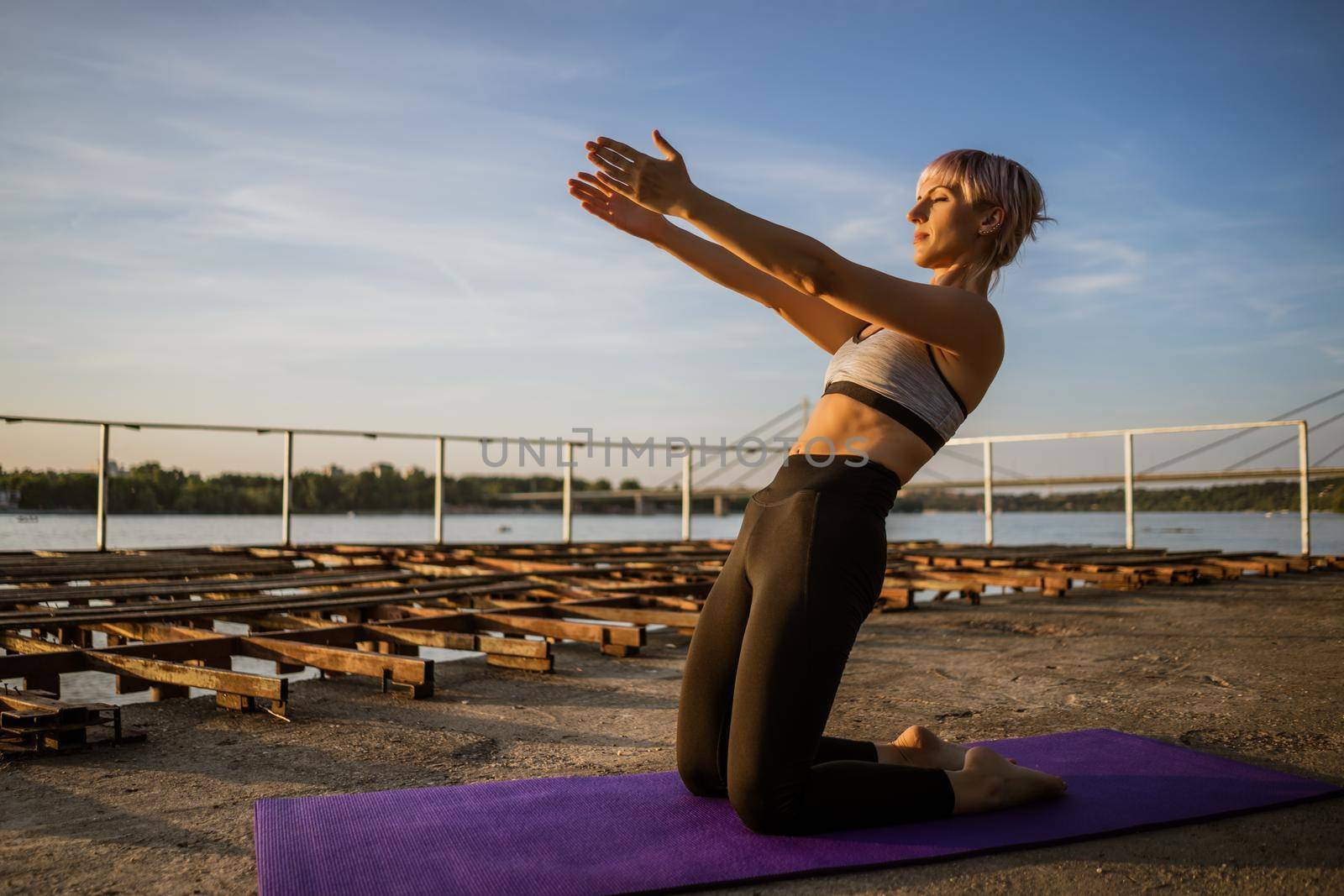 Woman exercising pilates on sunny day.