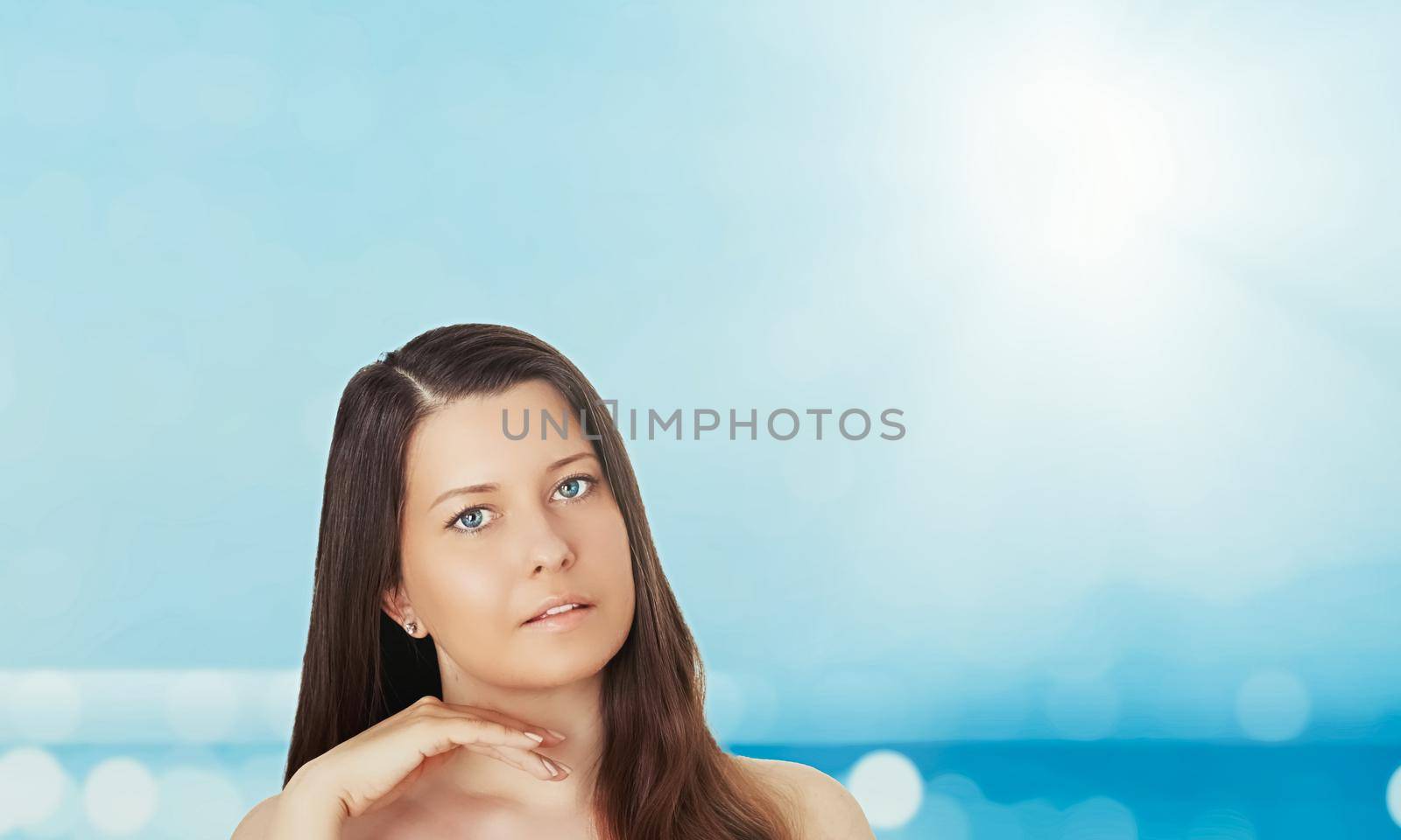 Skincare and sun protection in summer. Portrait of a beautiful young suntanned woman, blue sea and sky on background, beauty, wellness and travel concept.