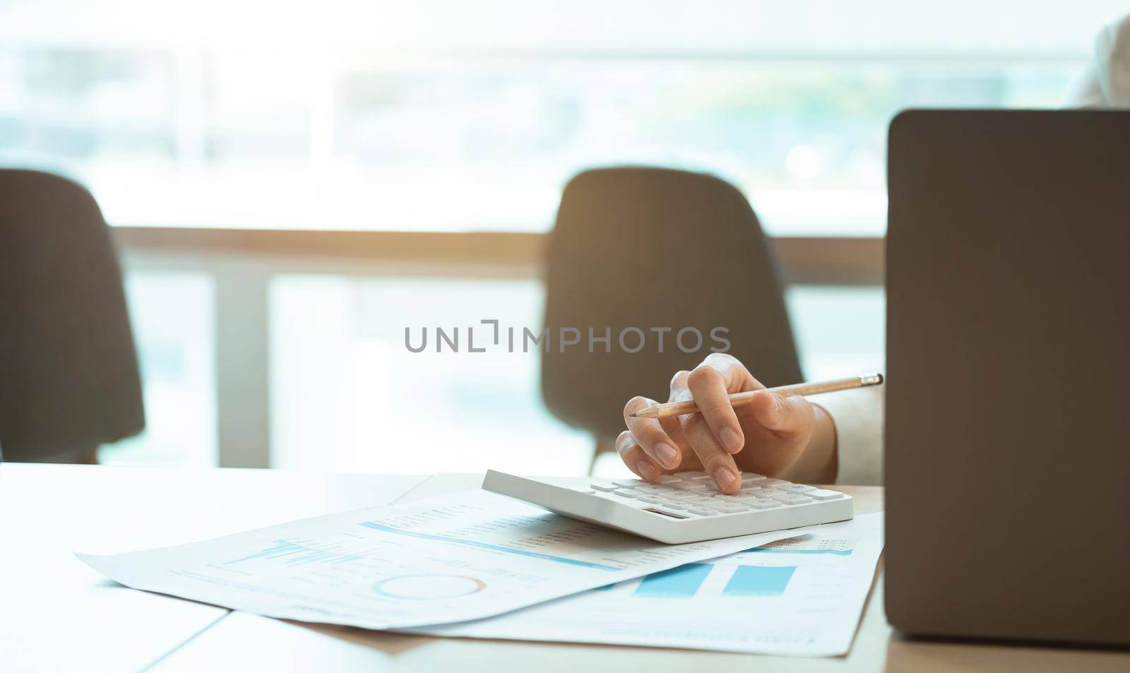 Close up accounting or businesswoman calculating income-expenditure and analyzing real estate investment data, Dedicated to the progress and growth of the company, Financial and tax systems concept.
