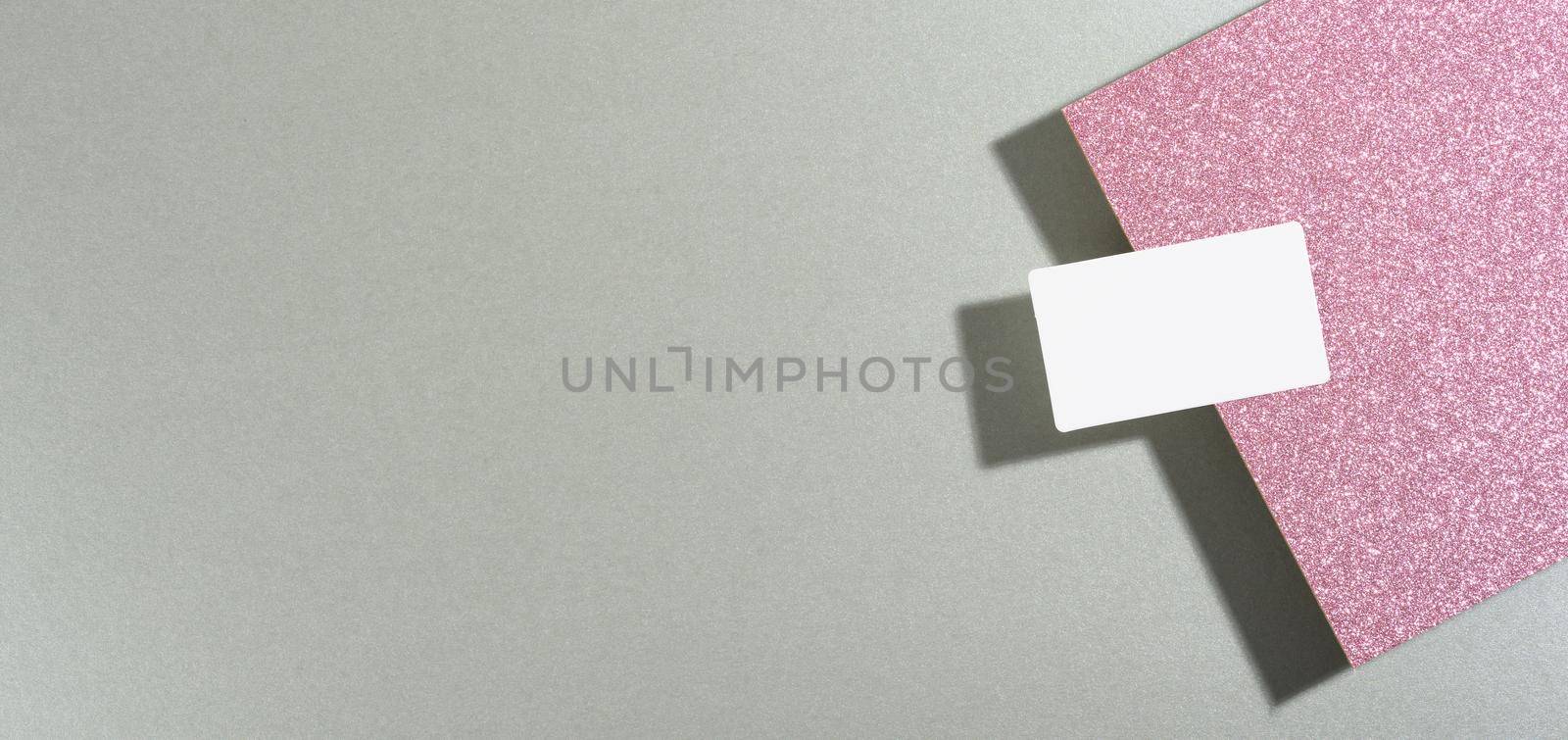 blank rectangular business card lies on a modern gray background sheets of paper with a shadow. Business template, flat lay