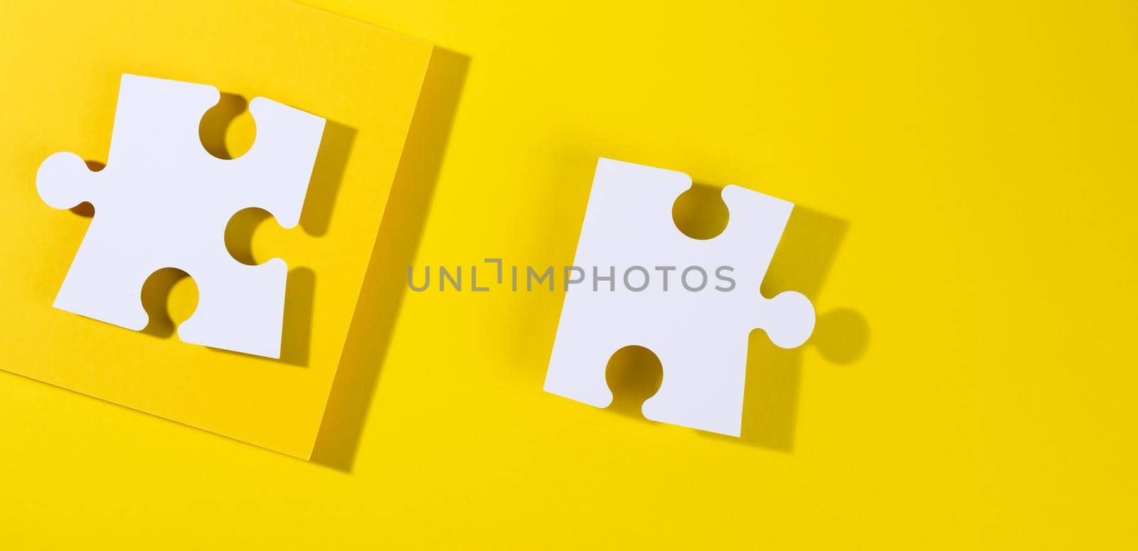 large blank white paper puzzle with shadow on yellow background, top view. Abstract creative backdrop for designer, flat lay