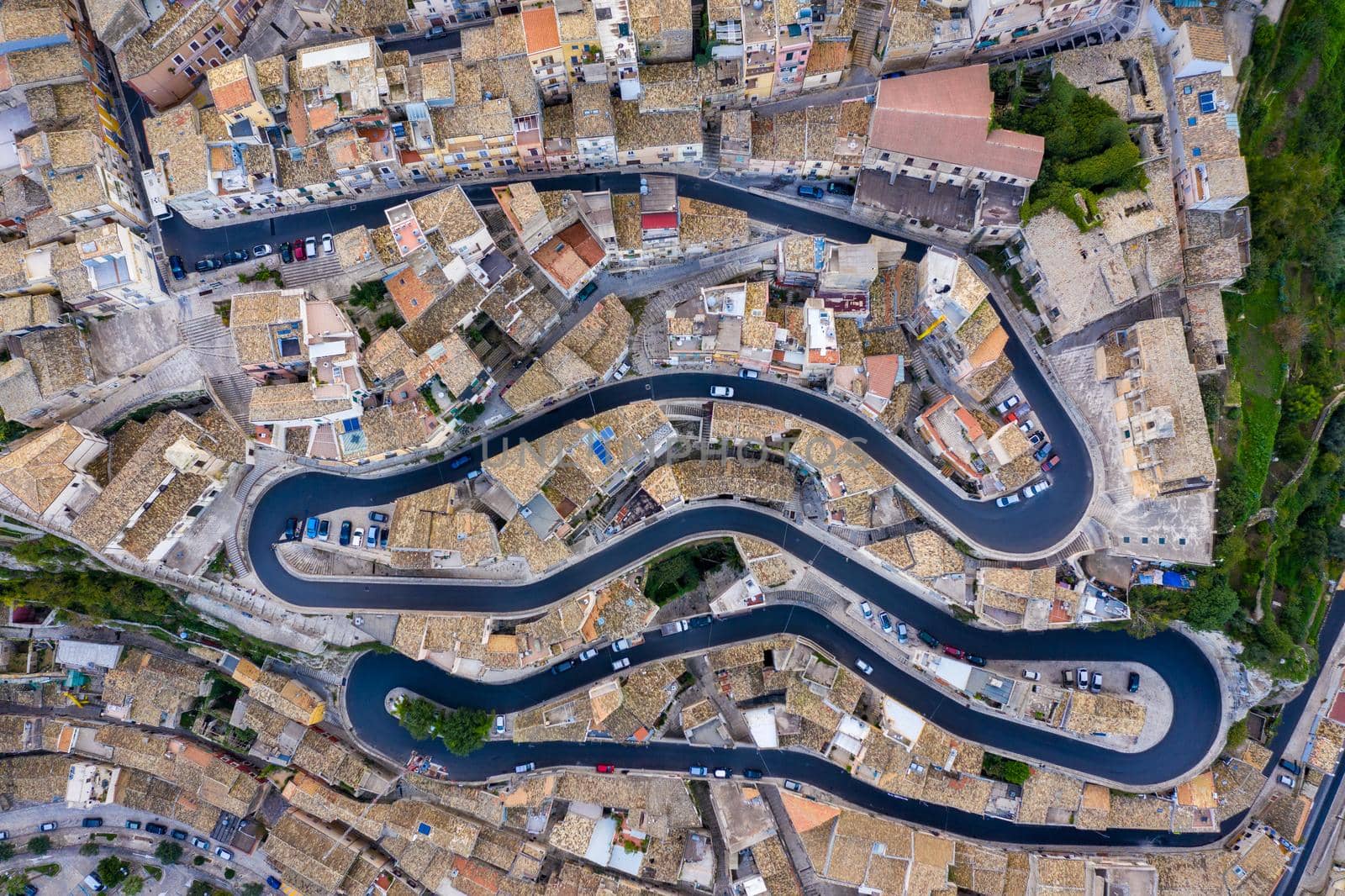 Aerial view of the old town of Ragusa Ibla and a winding road. View from above of the city in Ragusa Ibla, Province of Ragusa, Val di Noto, Sicily, Italy. 