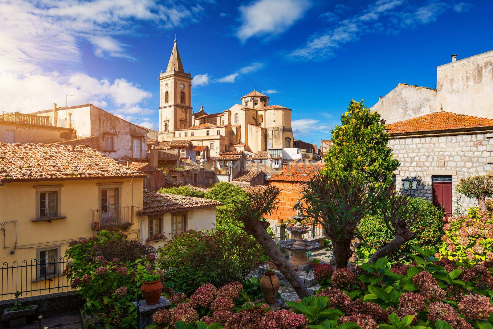 Picturesque street with the Duomo in the background in Novara di Sicilia, Sicily, Italy. Amazing cityscape of Novara di Sicilia town. Mountain village Novara di Sicilia, Sicily, Italy.