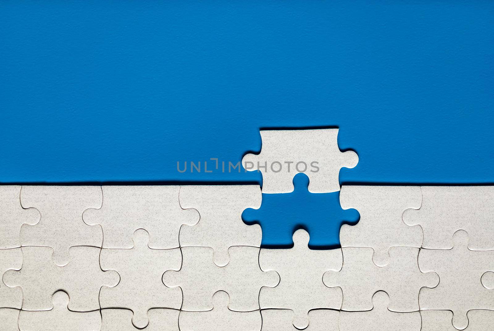 White jigsaw puzzle pieces. Fill in pieces of the jigsaw puzzle. Complete the jigsaw puzzle with the missing pieces. Fragment of a folded white jigsaw puzzle.