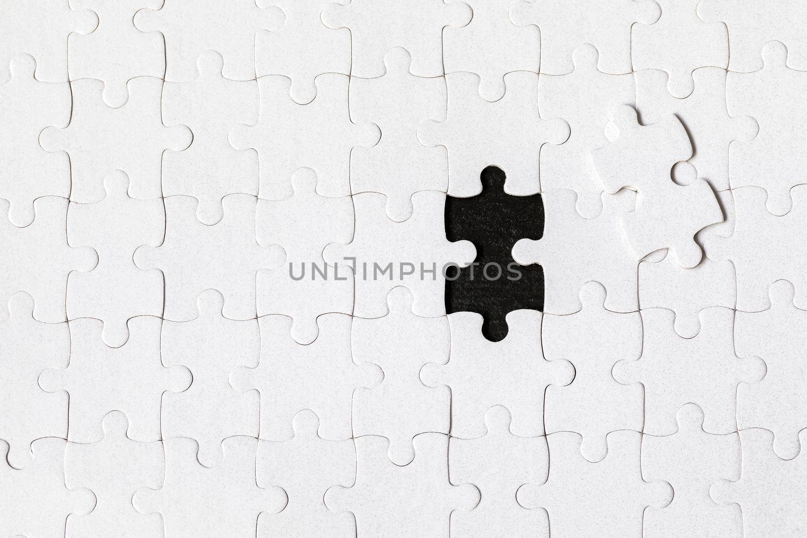 White jigsaw puzzle. White puzzle pieces on color background. Unfinished white jigsaw puzzle pieces on color background. 