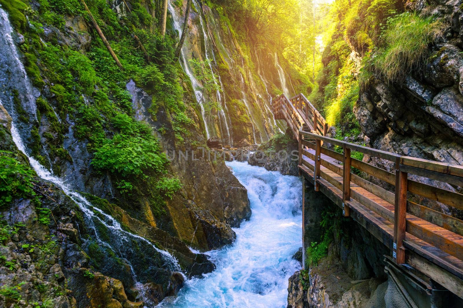 Beautiful Wimbachklamm gorge with wooden path in autumn colors, Ramsau bei Berchtesgaden in Germany. Waterfall at Wimbachklamm near Ramsau-Berchtesgaden, Bavaria, Germany.