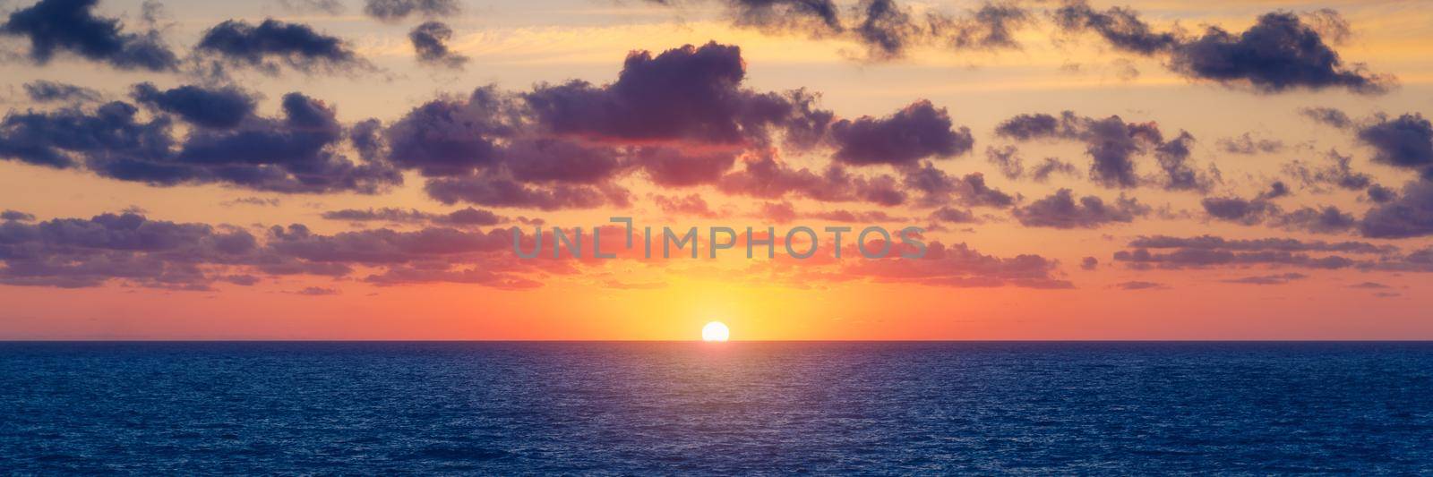 Beautiful sunset/sunrise over the sea. Beautiful sunset over the ocean. Beautiful sunset over sea with reflection in water, majestic clouds in the sky by DaLiu