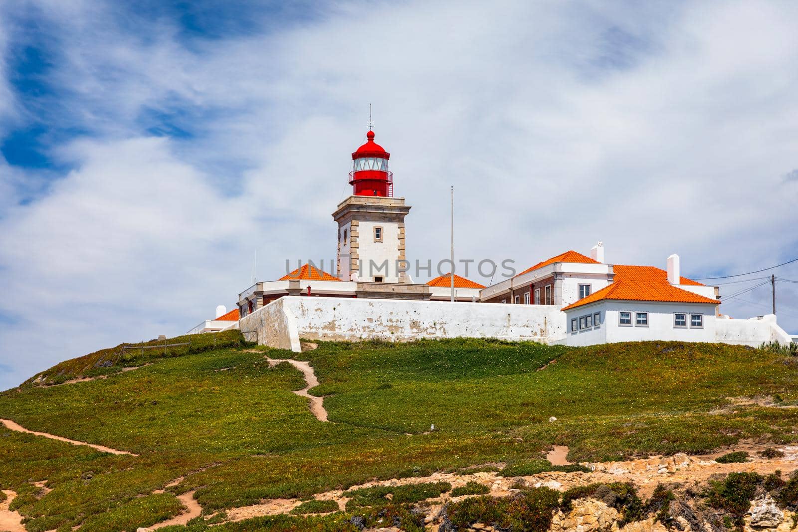 The lighthouse in Cabo da Roca. Cliffs and rocks on the Atlantic ocean coast in Sintra in a beautiful summer day, Portugal. Cabo da Roca, Portugal. Lighthouse and cliffs over Atlantic Ocean.