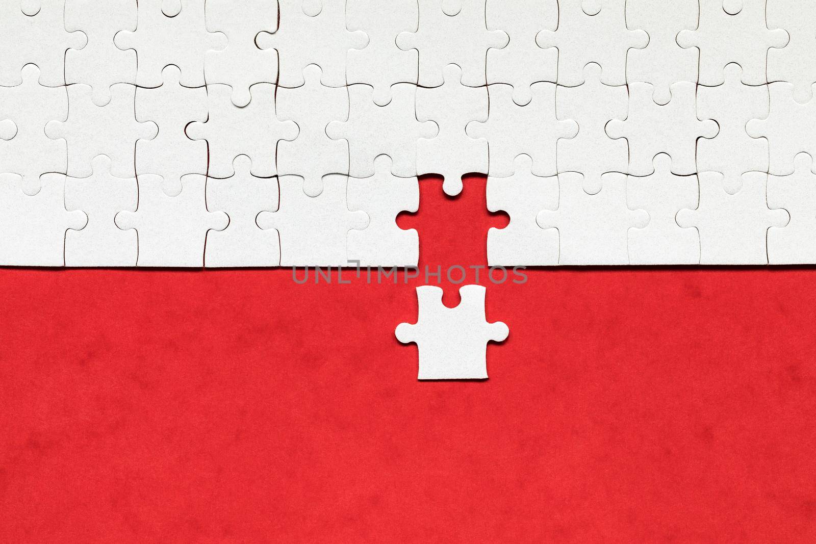 White jigsaw puzzle. White puzzle pieces on color background. Unfinished white jigsaw puzzle pieces on color background. 
