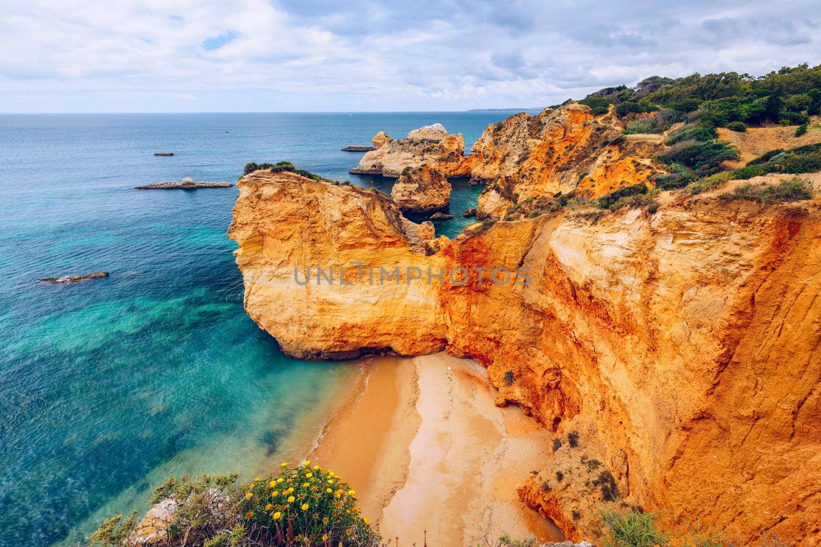 View of stunning beach with golden color rocks in Alvor town , Algarve, Portugal. View of cliff rocks on Alvor beach, Algarve region, Portugal.