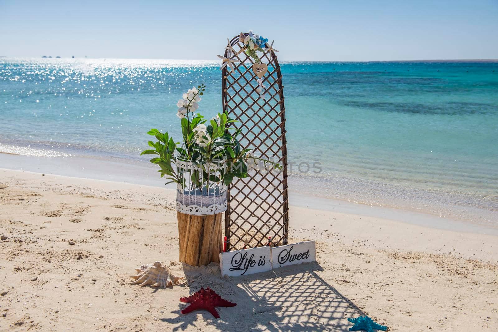 Closeup of wedding sign and decorations on tropical island sandy beach paradise with ocean in background