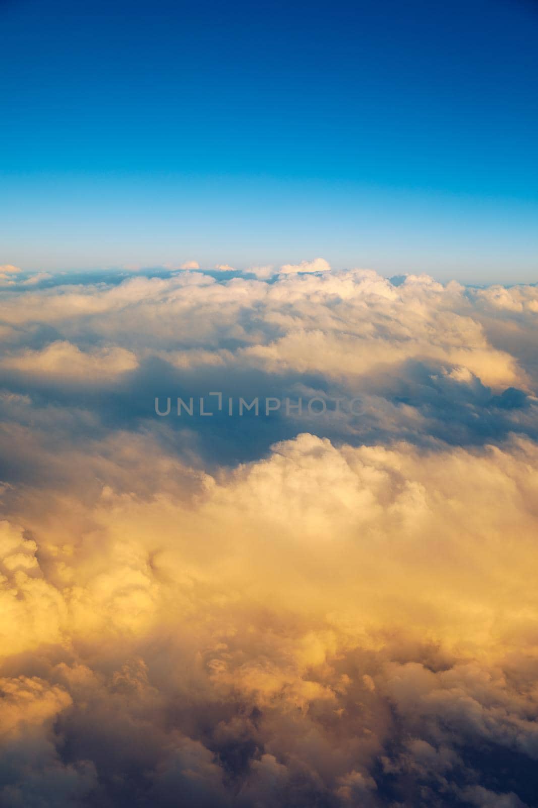 Sunny sky abstract background, beautiful cloudscape, on the heaven, view over white fluffy clouds, freedom concept. Aerial view of sky and white clouds. View from airplane. 