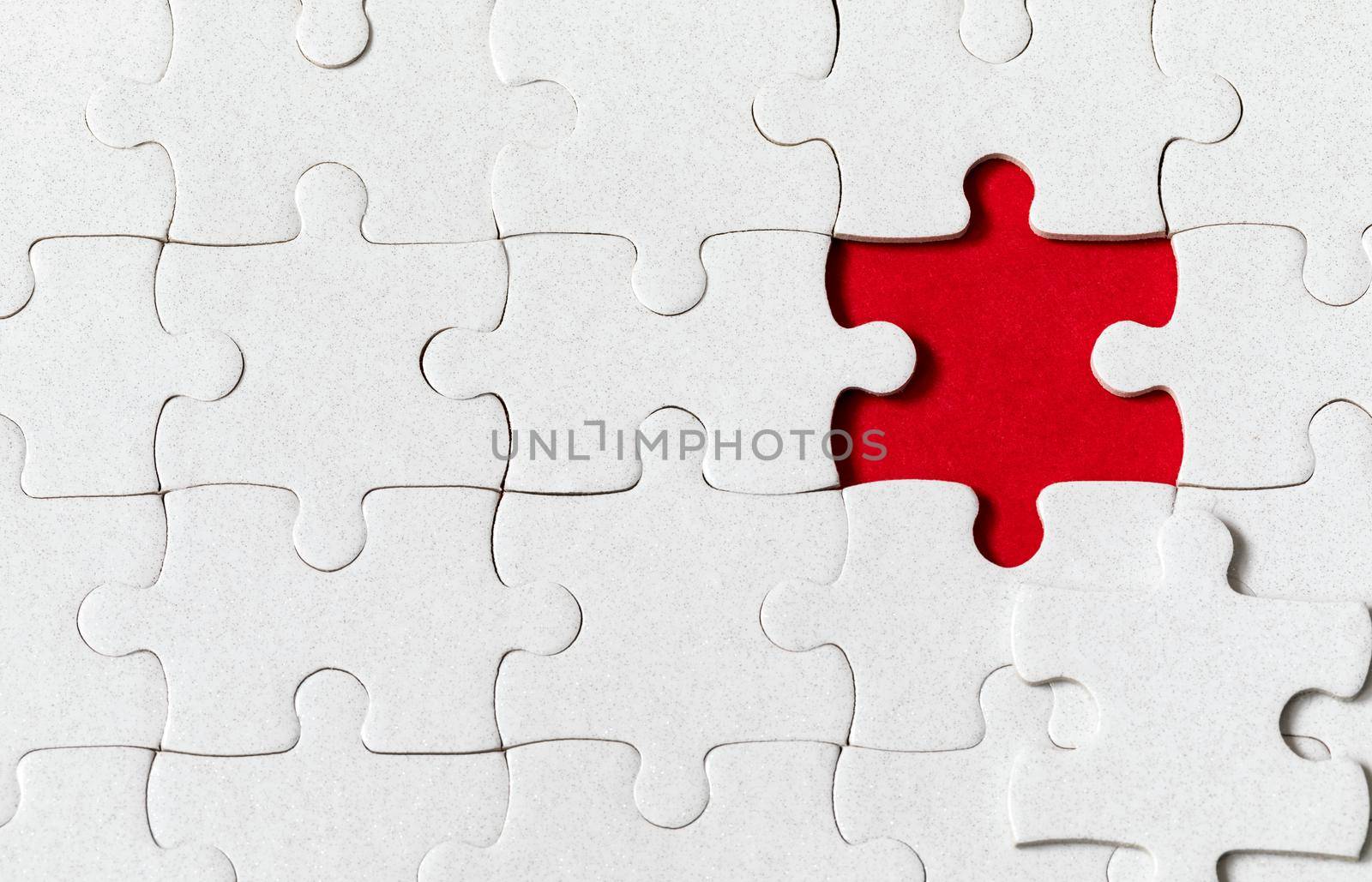 White jigsaw puzzle. White puzzle pieces on color background. Unfinished white jigsaw puzzle pieces on color background. 