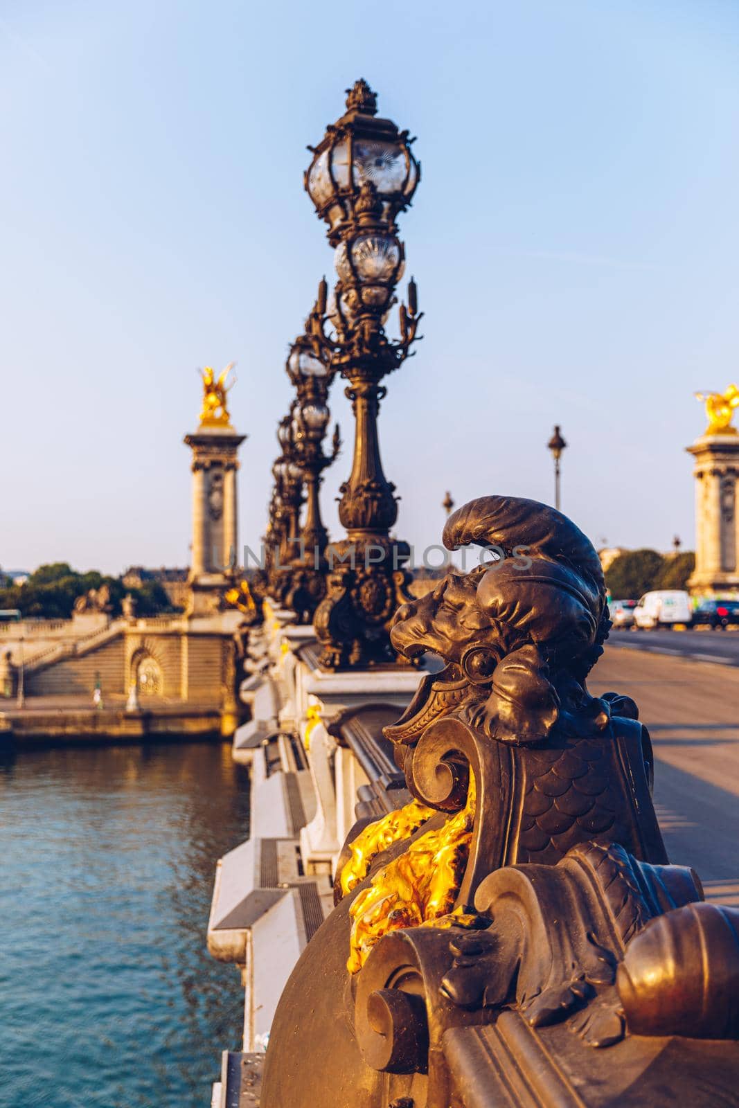 Pont Alexandre III bridge over river Seine in the sunny summer morning. Bridge decorated with ornate Art Nouveau lamps and sculptures. The Alexander III Bridge across Seine river in Paris, France.