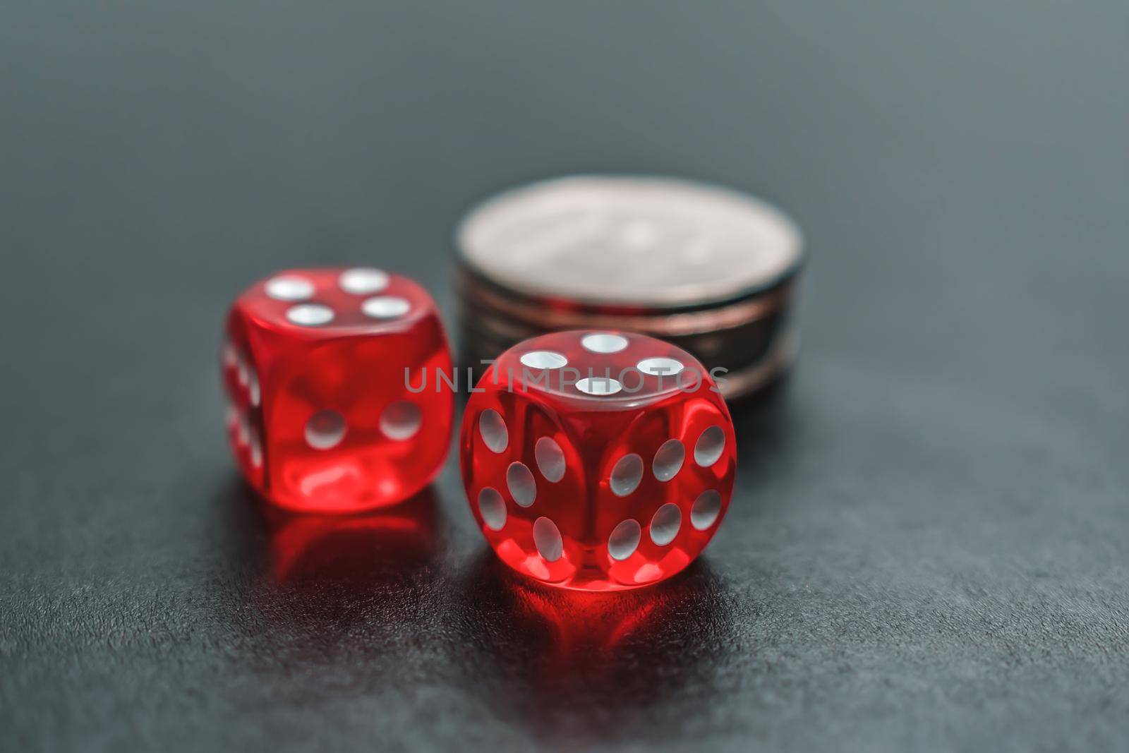 Red dice and chips lie on the gambling table for the casino. Casino gambling and home entertainment