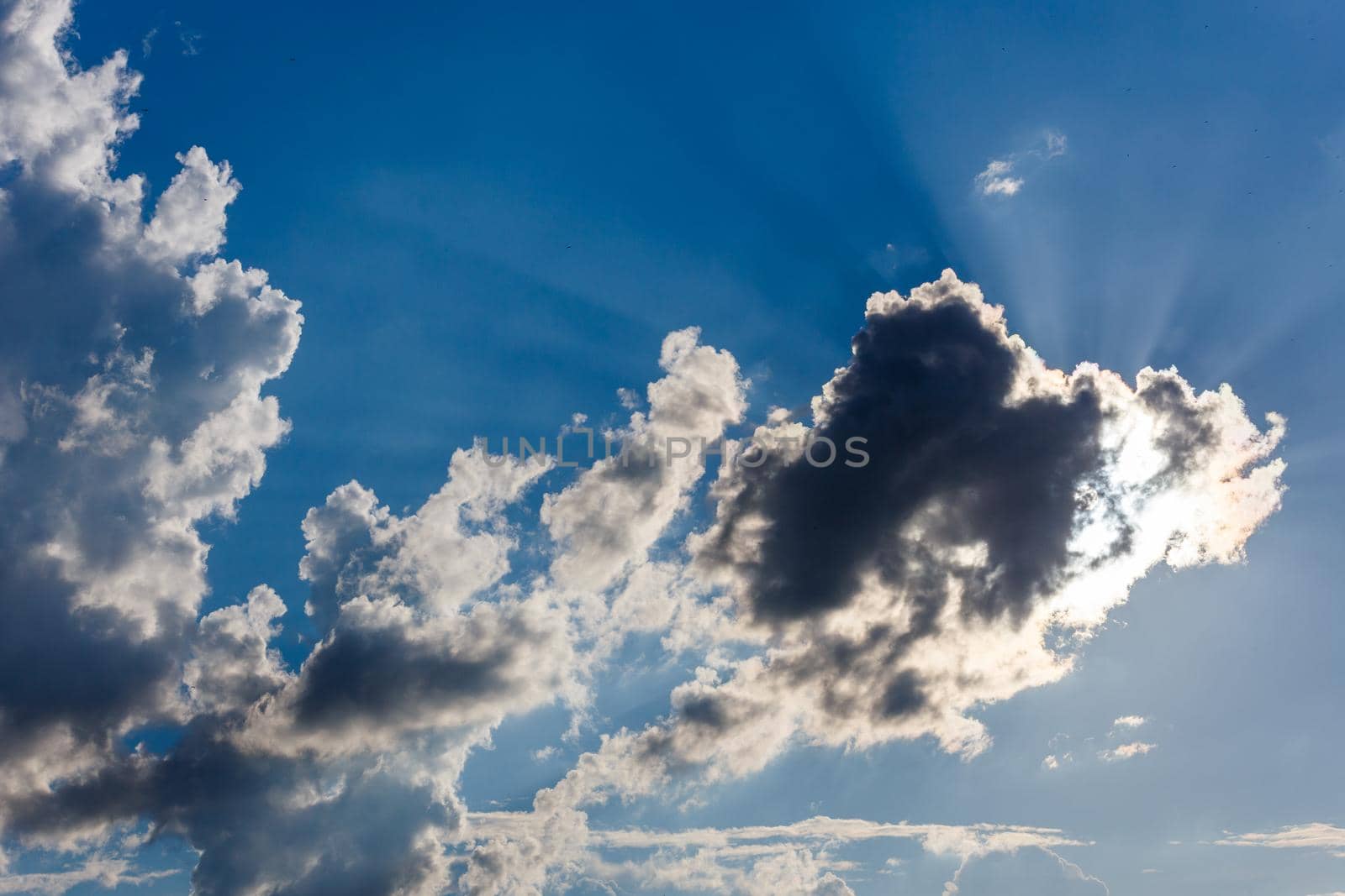 white c cumulus clouds on blue sky background telephoto view