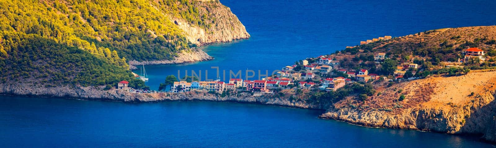 Assos village in Kefalonia, Greece. Turquoise colored bay in Mediterranean sea with beautiful colorful houses in Assos village in Kefalonia, Greece, Ionian island, Cephalonia, Assos village.