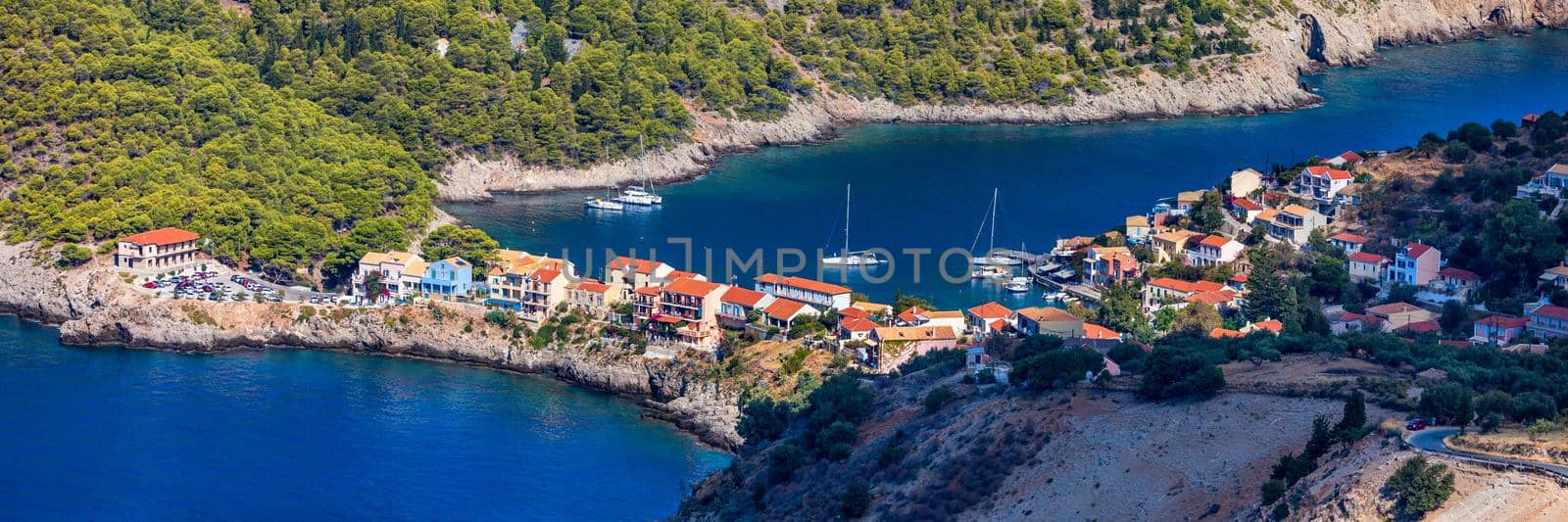 Assos village in Kefalonia, Greece. Turquoise colored bay in Mediterranean sea with beautiful colorful houses in Assos village in Kefalonia, Greece, Ionian island, Cephalonia, Assos village.