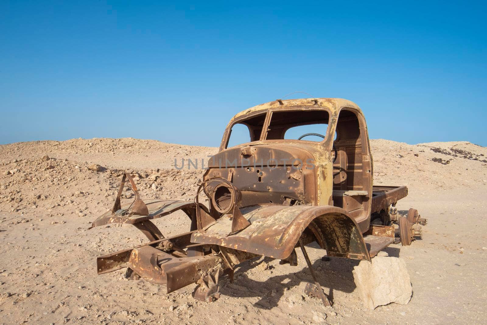 Remains of a rusty old abandoned derelict truck left in the desert to decay