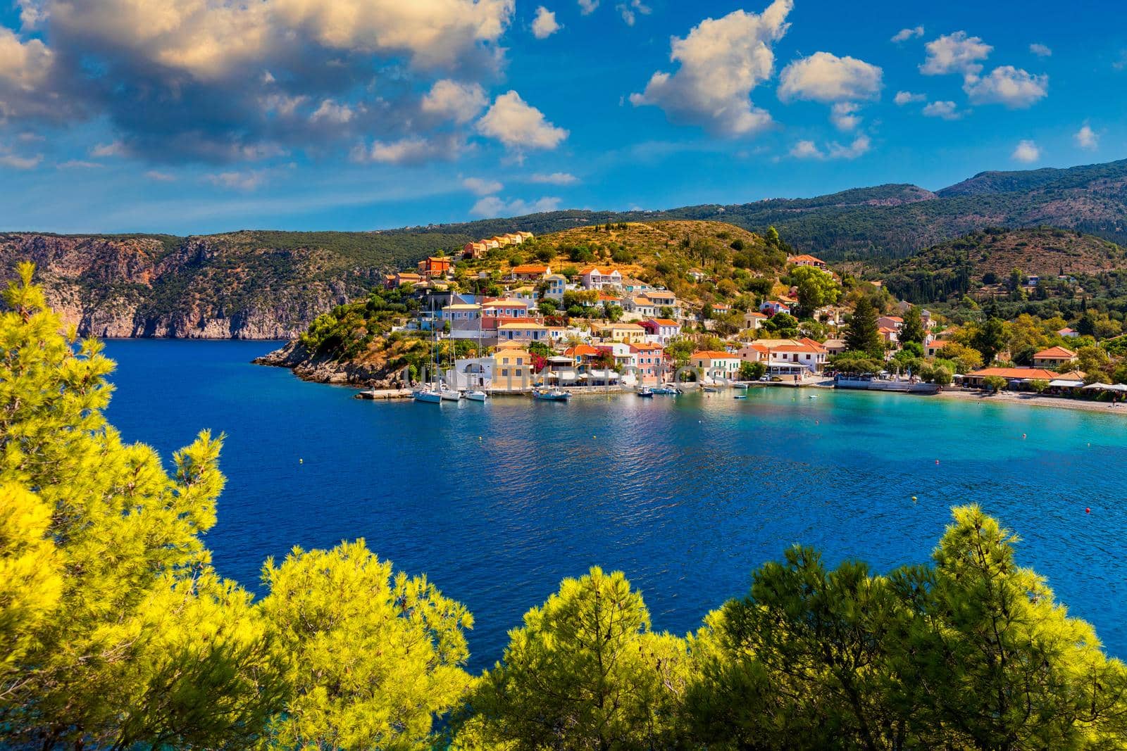 Assos village in Kefalonia, Greece. Turquoise colored bay in Mediterranean sea with beautiful colorful houses in Assos village in Kefalonia, Greece, Ionian island, Cephalonia, Assos village.