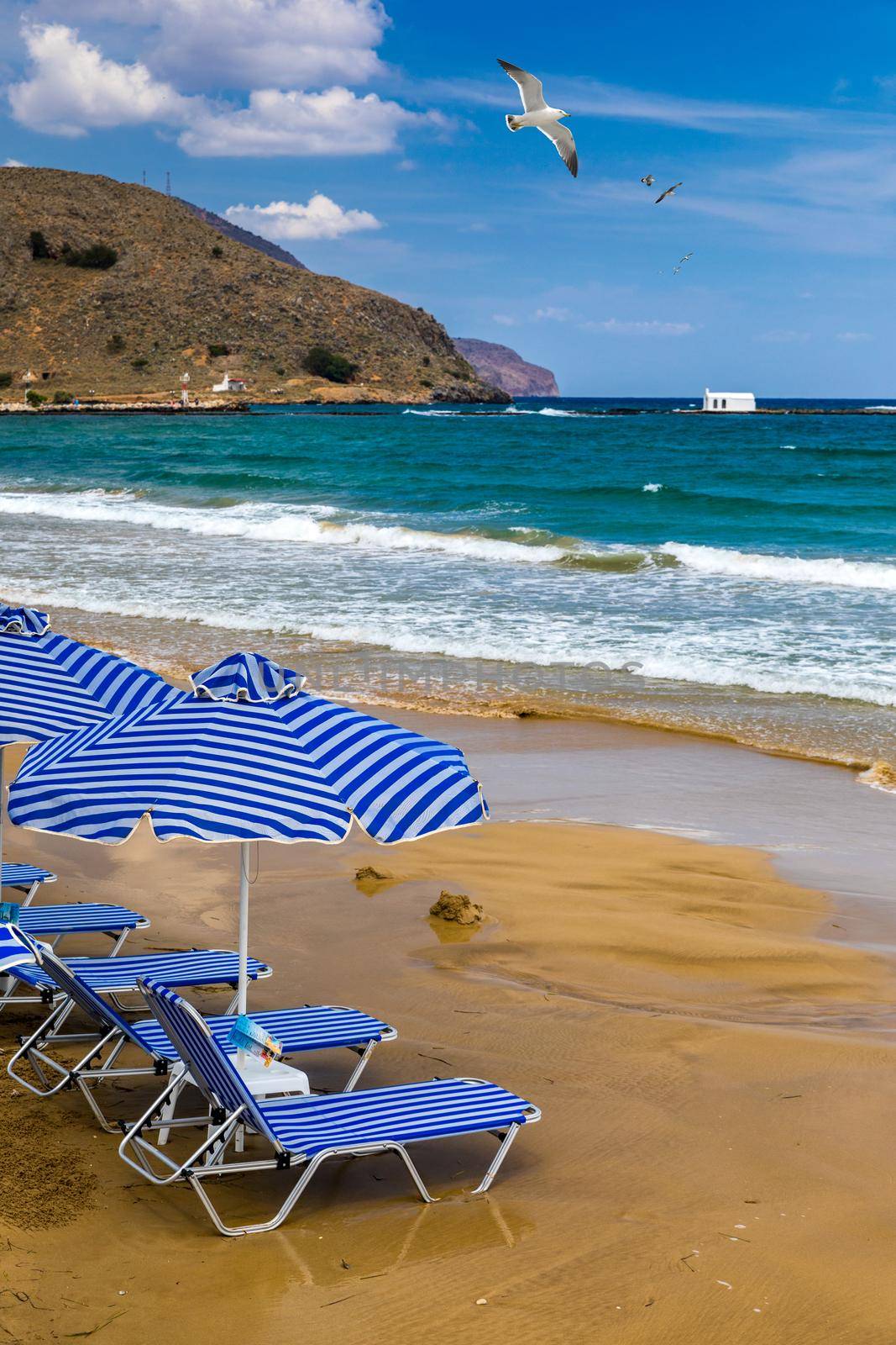 View of sunbeds awaiting tourists at the Greek island resort of Georgioupolis on Crete north coast. Georgioupoli is a resort village and former municipality in the Chania regional unit, Crete, Greece.