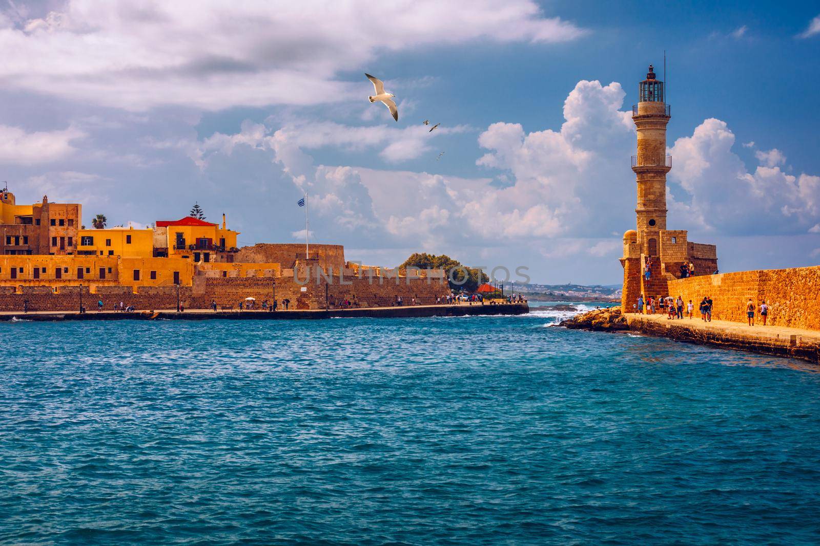 Panorama of venetian harbour waterfront and lighthouse in old harbour of Chania, Crete, Greece. Old venetian lighthouse in Chania, Greece. Lighthouse of the old Venetian port in Chania, Greece.