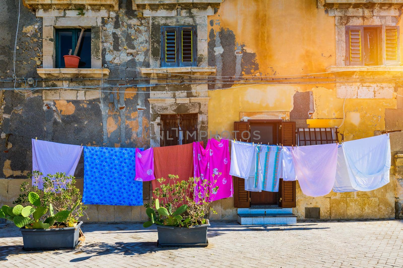 Siracusa (Syracuse) in a sunny summer day. Sicily, Italy. The clothes being dried in the narrow street of the famous historic town Syracuse, Sicily.
