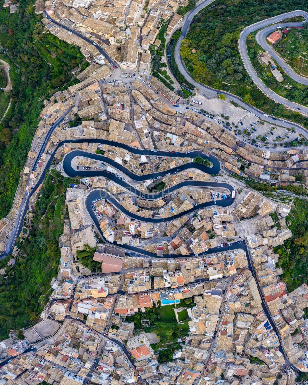 Aerial view of the old town of Ragusa Ibla and a winding road. View from above of the city in Ragusa Ibla, Province of Ragusa, Val di Noto, Sicily, Italy. 