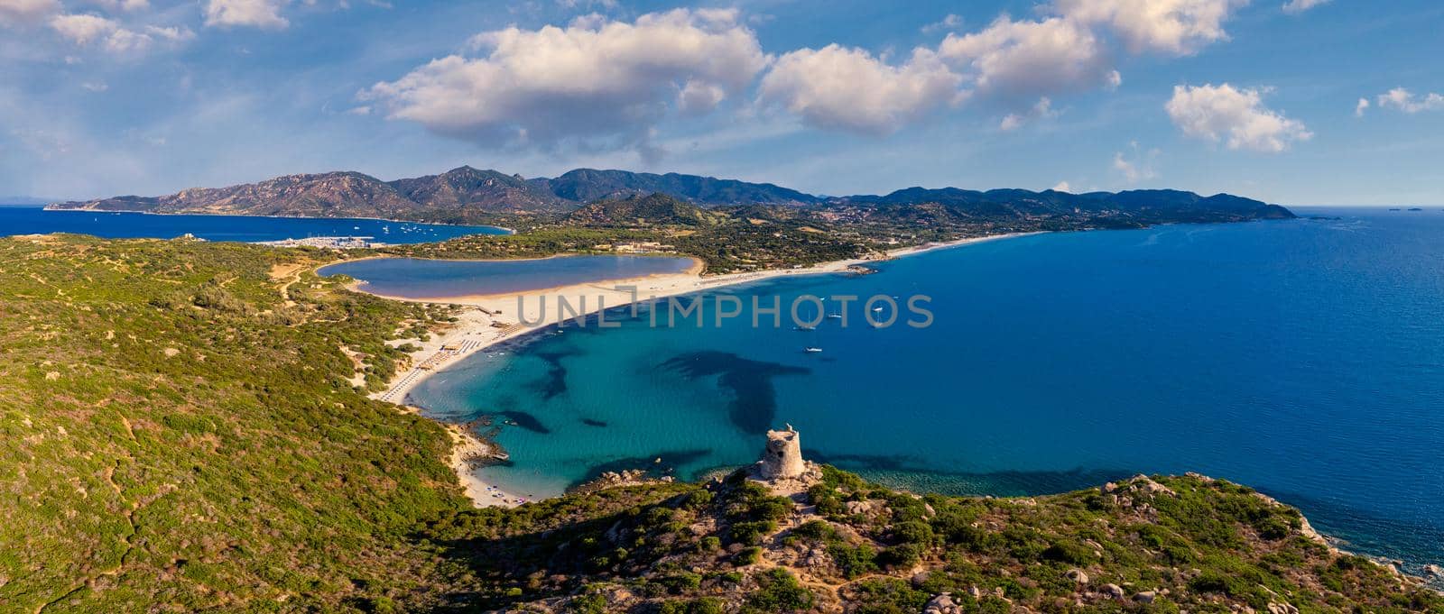 Torre di Porto Giunco Tower and Simius Beach near Villasimius, Sardinia, Italy. View from flying drone. Torre di Porto Giunco tower on Carbonara cape. Aerial morning view of Sardinia island, Italy