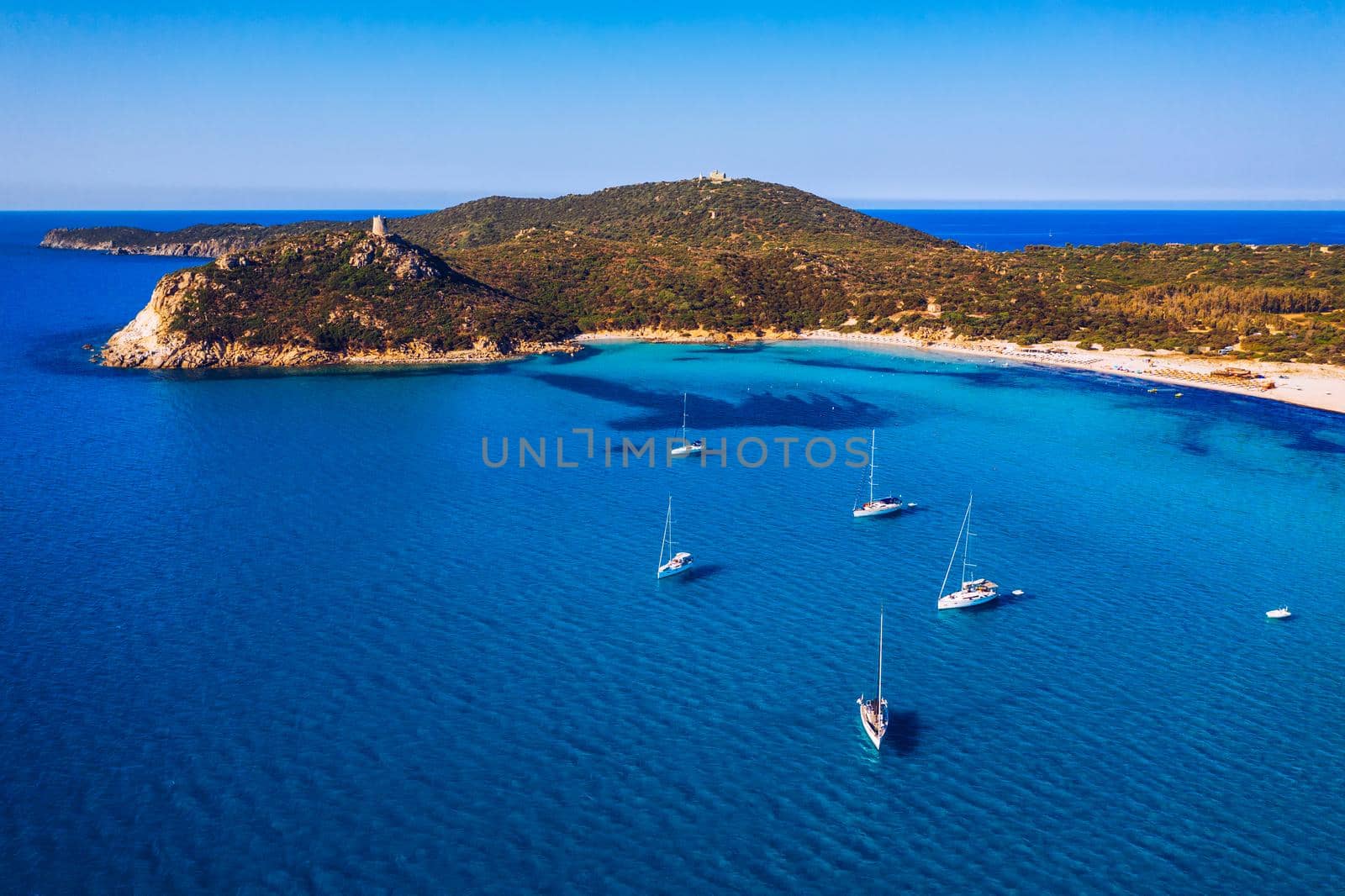 Torre di Porto Giunco Tower and Simius Beach near Villasimius, Sardinia, Italy. View from flying drone. Torre di Porto Giunco tower on Carbonara cape. Aerial morning view of Sardinia island, Italy