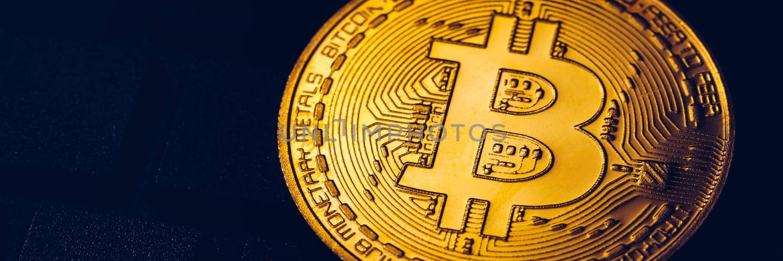 Bitcoin on compuer keyboard in background, symbol of electronic virtual money and mining cryptocurrency concept. Coin crypto currency bitcoin lies on the keyboard. Bitcoin on keyboard.