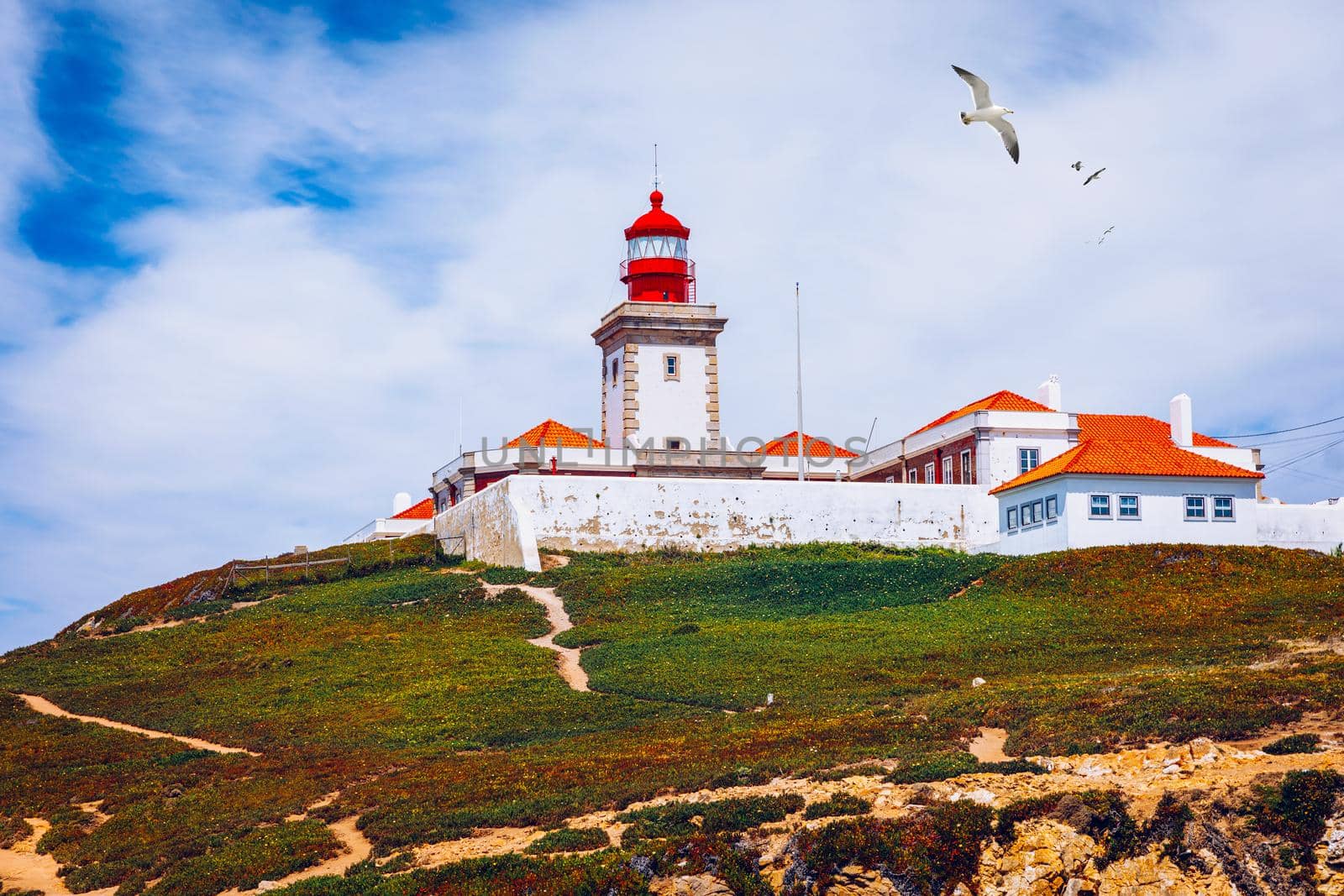 The lighthouse in Cabo da Roca. Cliffs and rocks on the Atlantic ocean coast in Sintra in a beautiful summer day, Portugal. Cabo da Roca, Portugal. Lighthouse and cliffs over Atlantic Ocean.