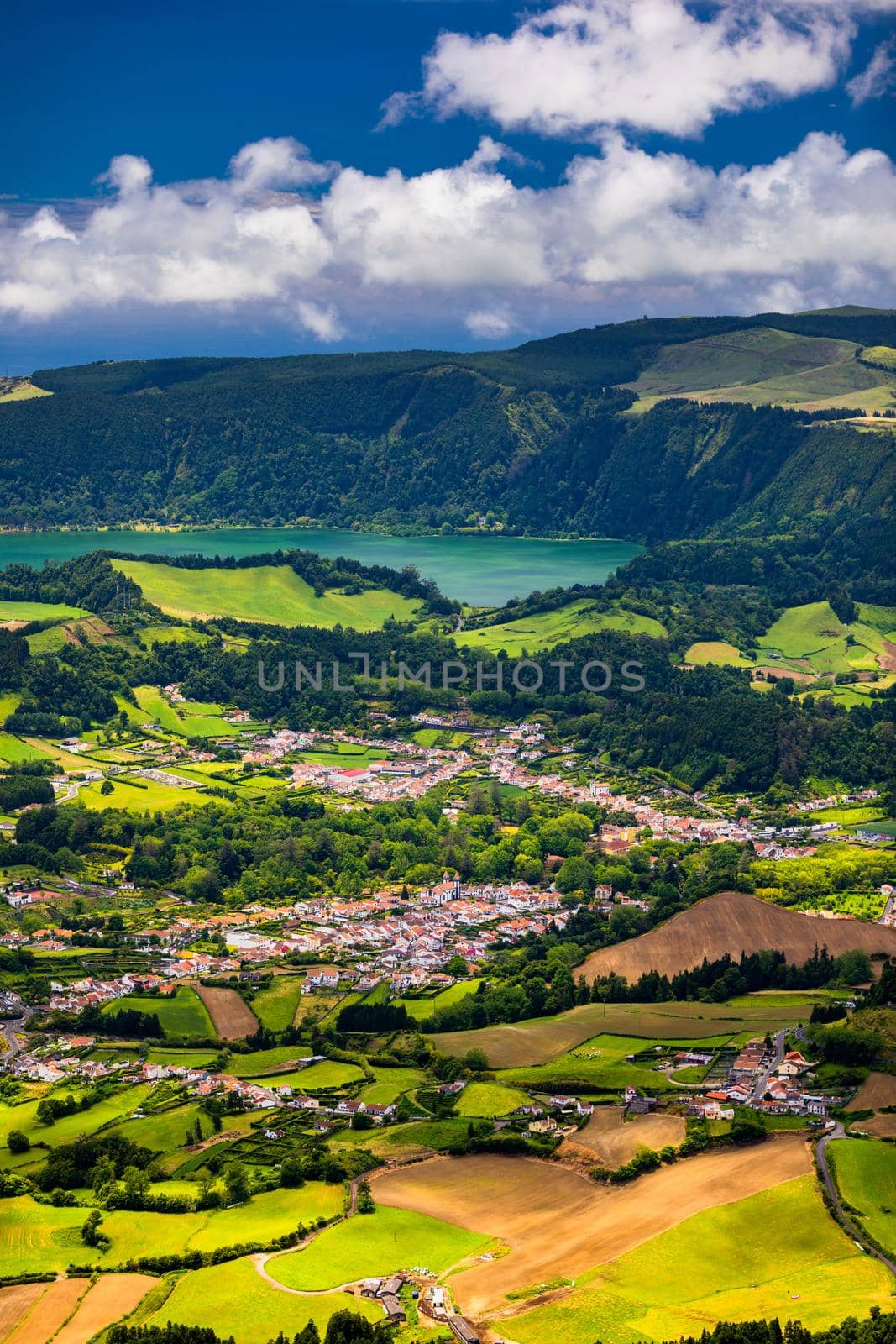 View of Furnas town and lake (Lagoa das Furnas) on Sao Miguel Island, Azores, Portugal from the Miradouro do Salto do Cavalo viewpoint. A tranquil scene of lush foliage and town in a volcanic crater