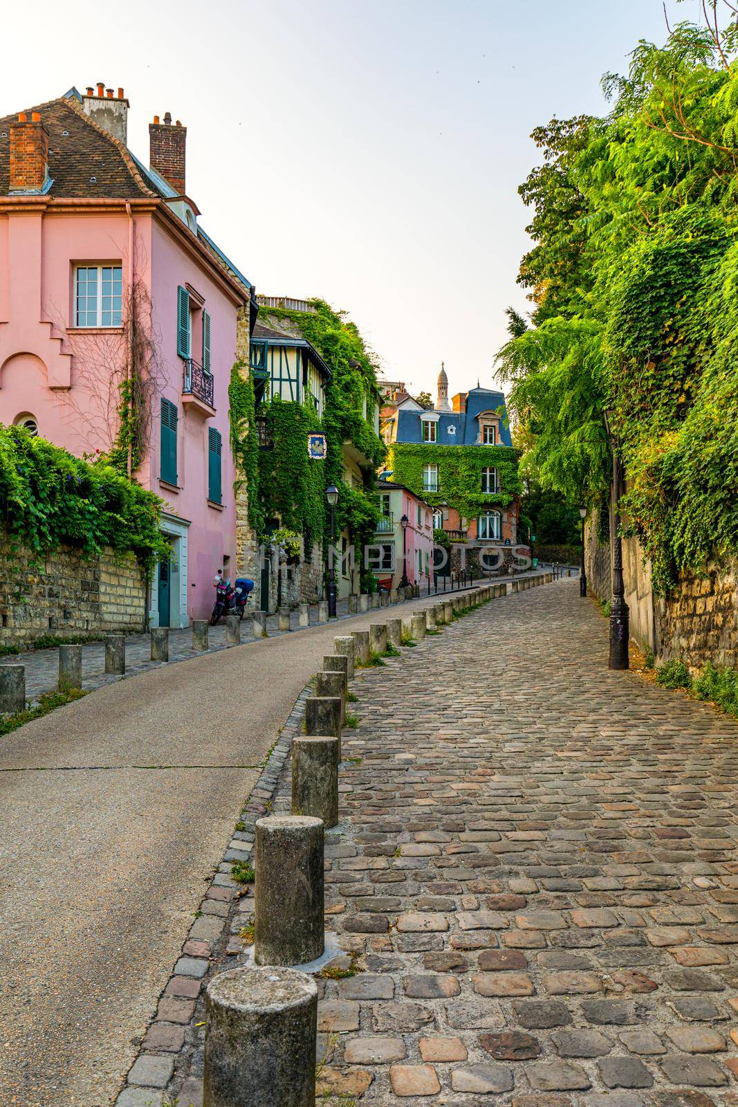 Montmartre district of Paris. Houses on narrow road in Montmartre district of Paris. View of cozy street in quarter Montmartre in Paris, France. Architecture and landmarks of Paris. Postcard of Paris.