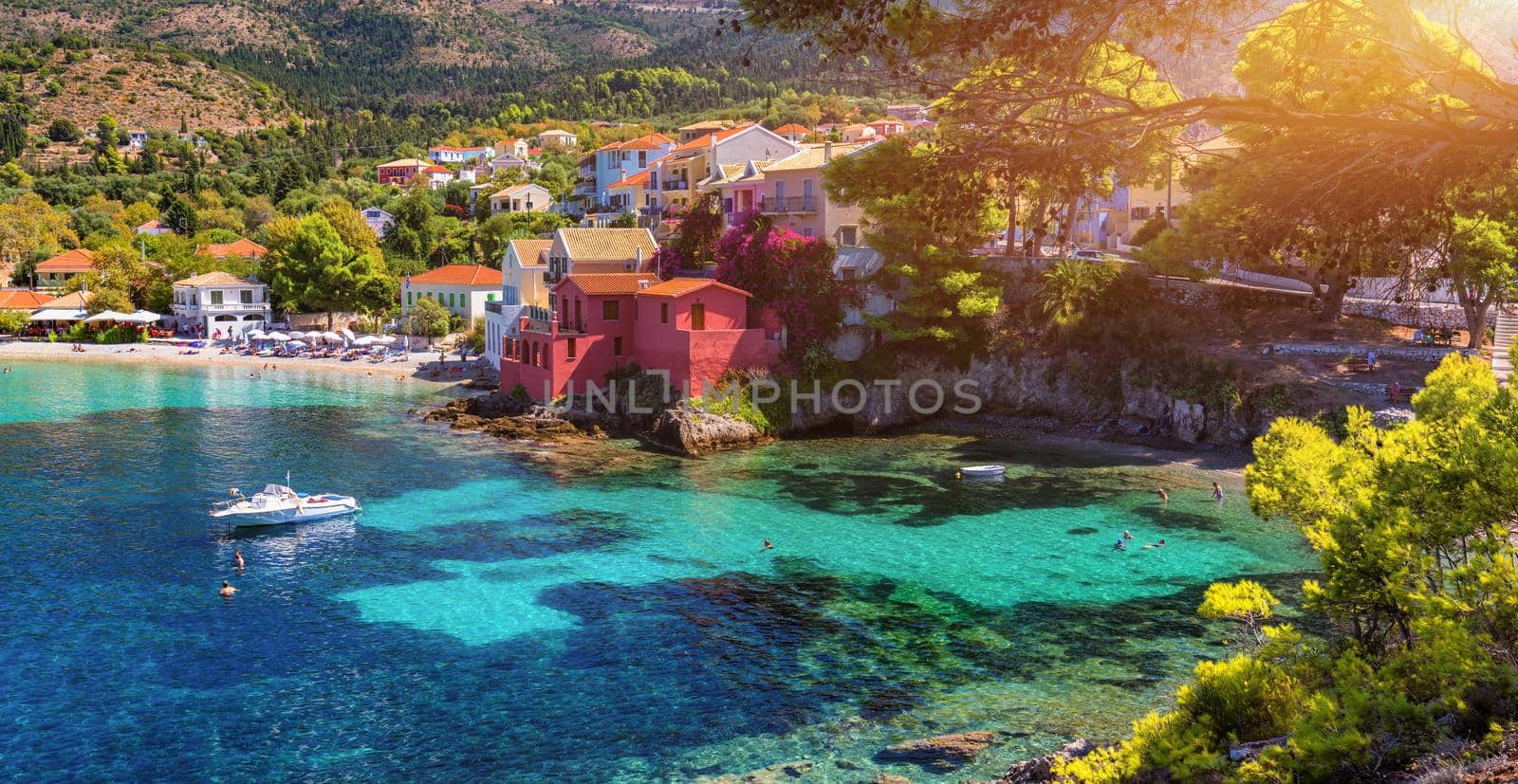 Assos village in Kefalonia, Greece. Turquoise colored bay in Mediterranean sea with beautiful colorful houses in Assos village in Kefalonia, Greece, Ionian island, Cephalonia, Assos village.