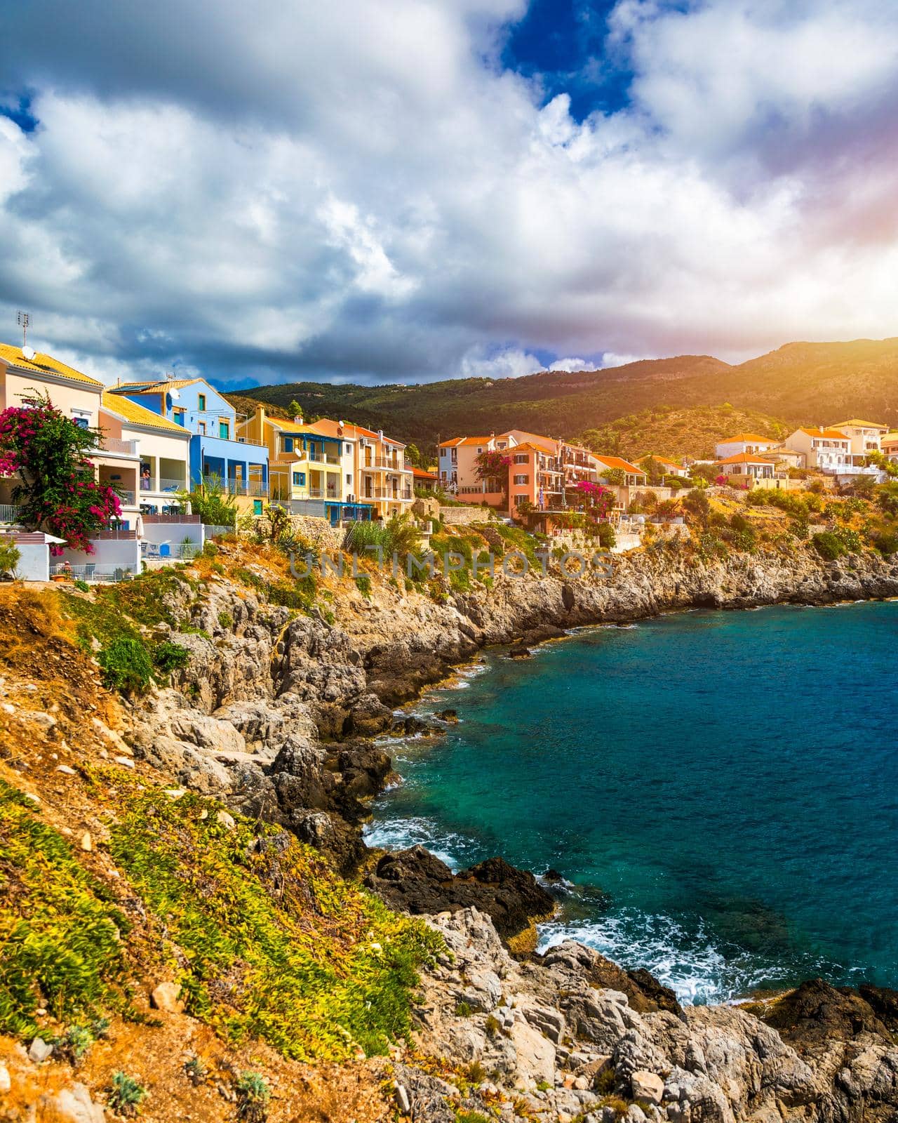 Turquoise colored bay in Mediterranean sea with beautiful colorful houses in Assos village in Kefalonia, Greece. Town of Assos with colorful houses on the mediterranean sea, Greece. 