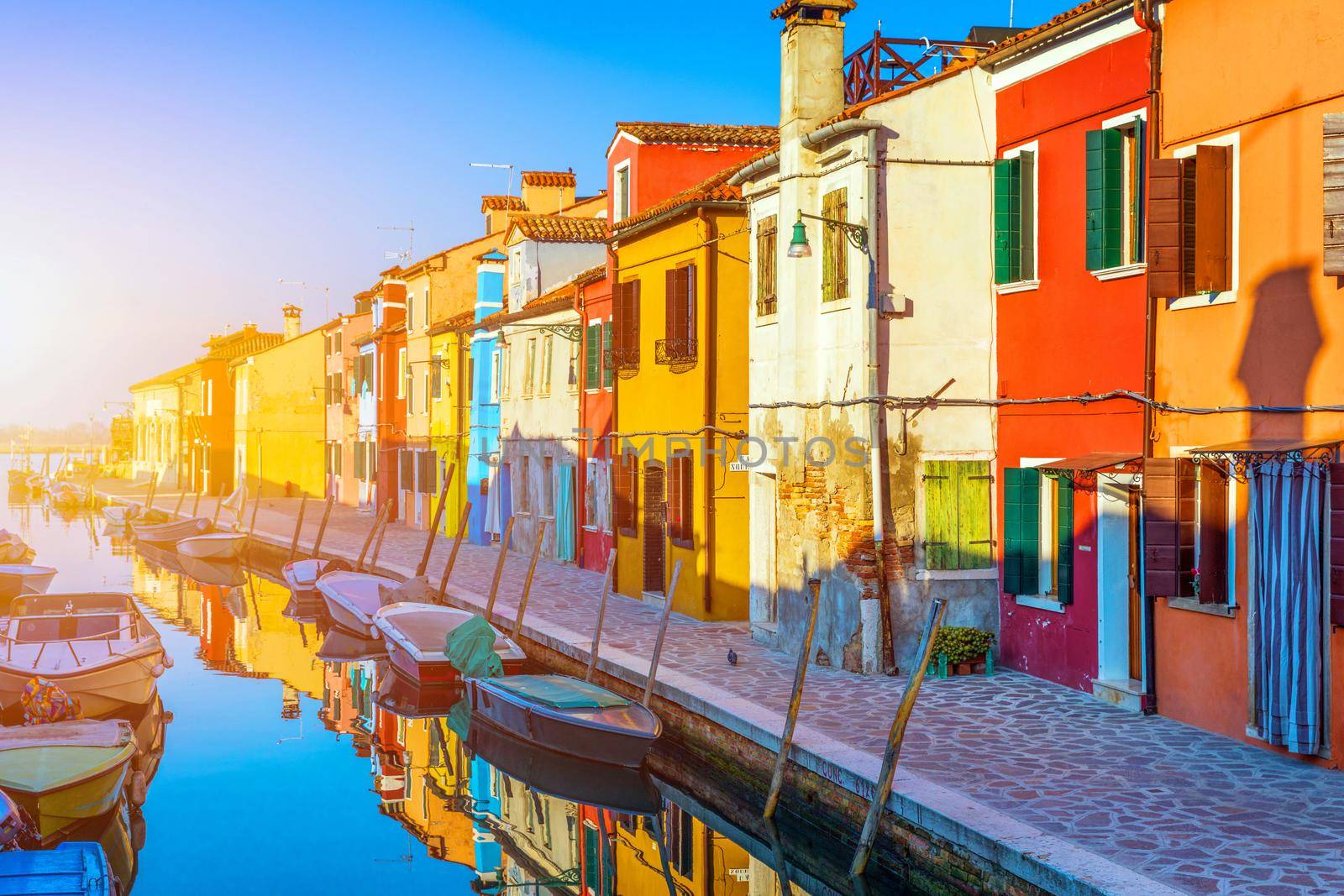 Street with colorful buildings in Burano island, Venice, Italy. Architecture and landmarks of Burano, Venice postcard. Scenic canal and colorful architecture in Burano island near Venice, Italy